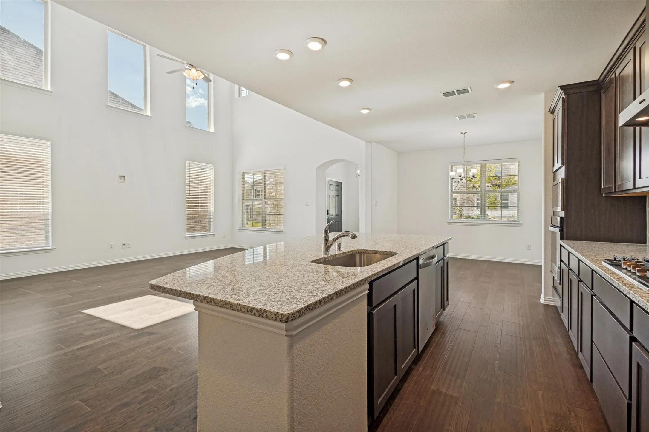 Kitchen island featuring a stainless steel sink, integrated dishwasher, and granite countertop
