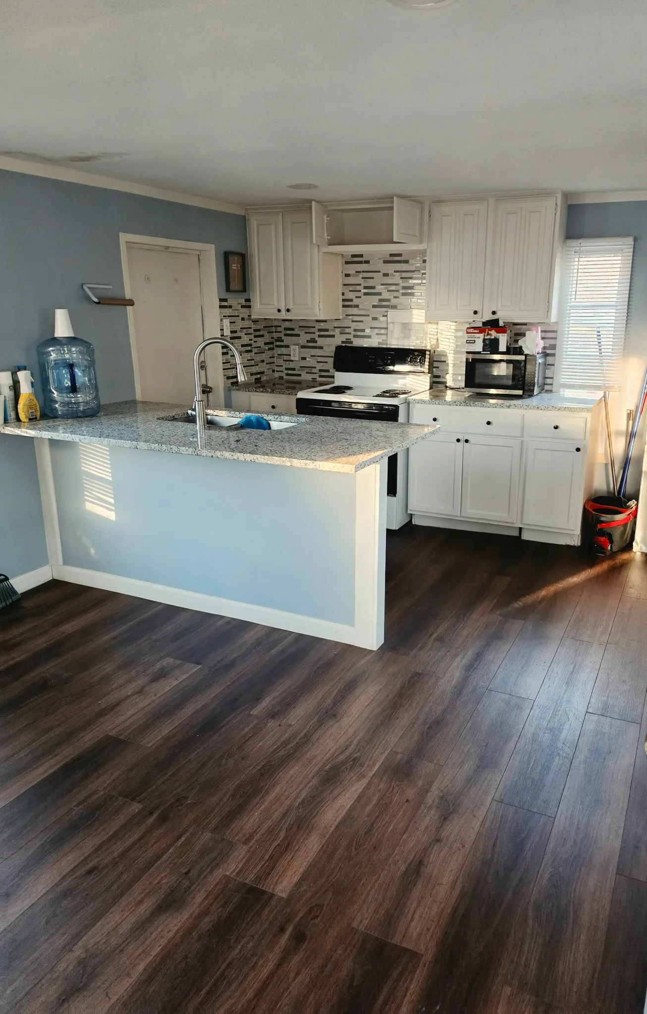 Kitchen area featuring dark wood-finish flooring
