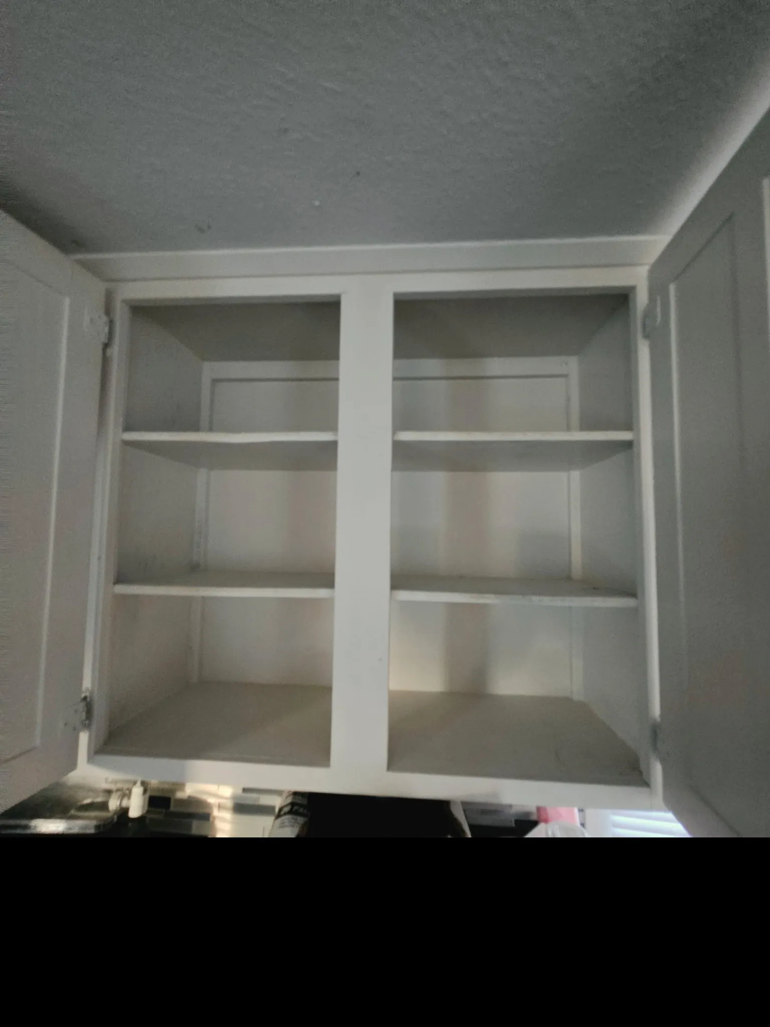 White upper kitchen cabinets featuring open doors and interior shelving