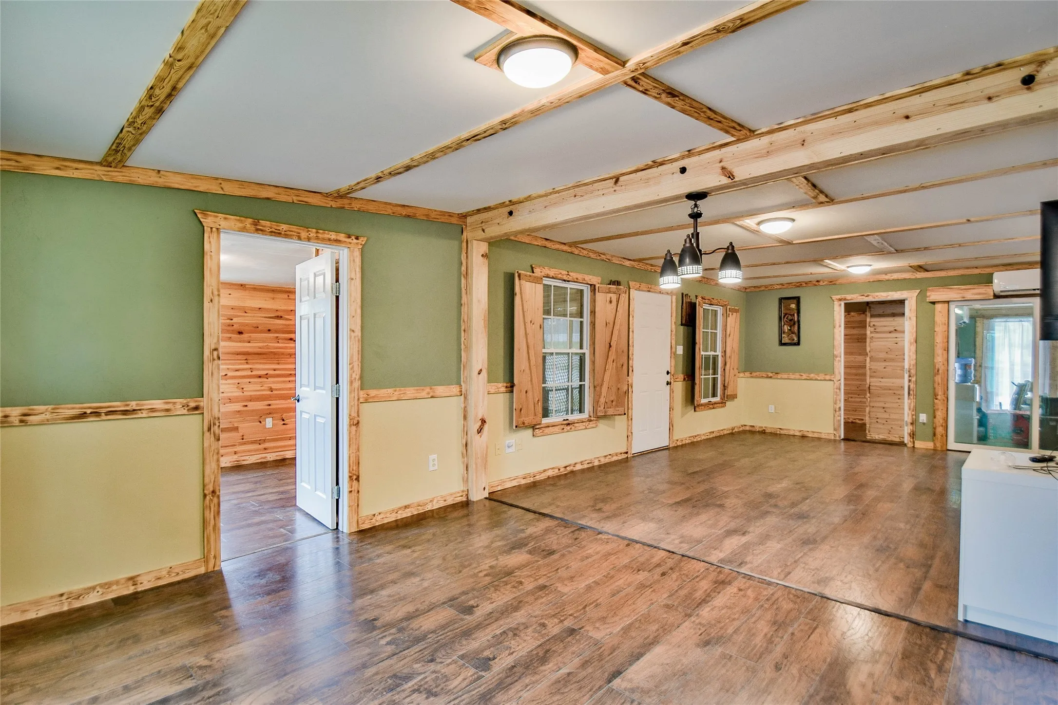 Extra living room opends to guest bedroom - great wood beams and laminate flooring provide the right touch for a modern rustic look.