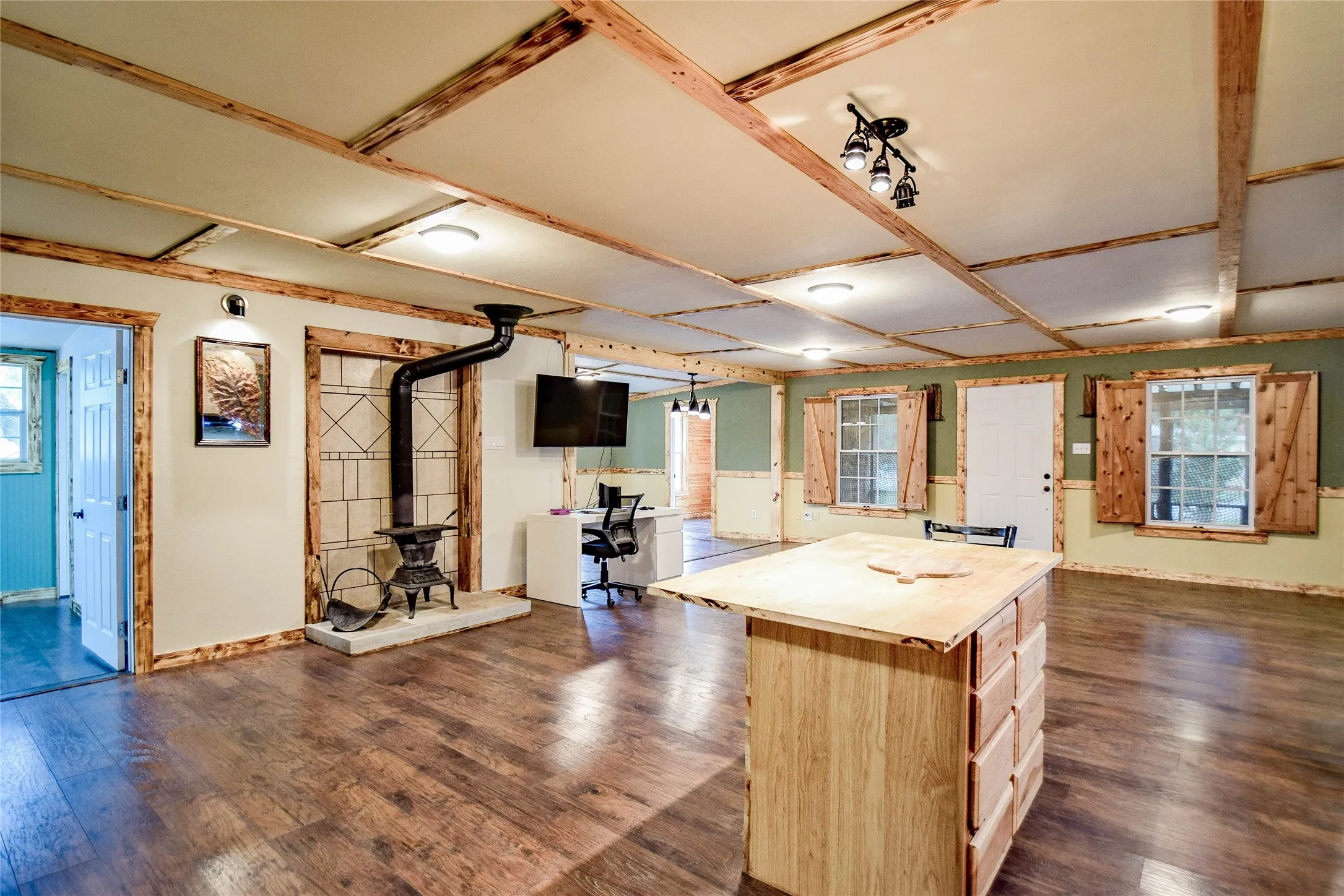 Spacious dining area beside the kitchen featuring a wood kitchen island and cross beamed ceiling.