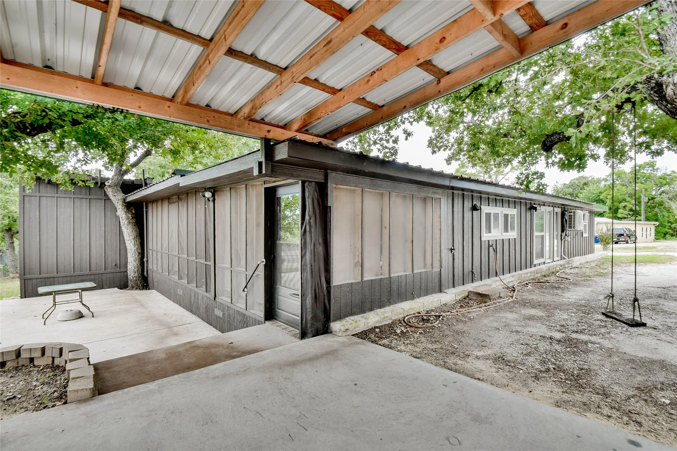 Back and side views of house under the carport.
