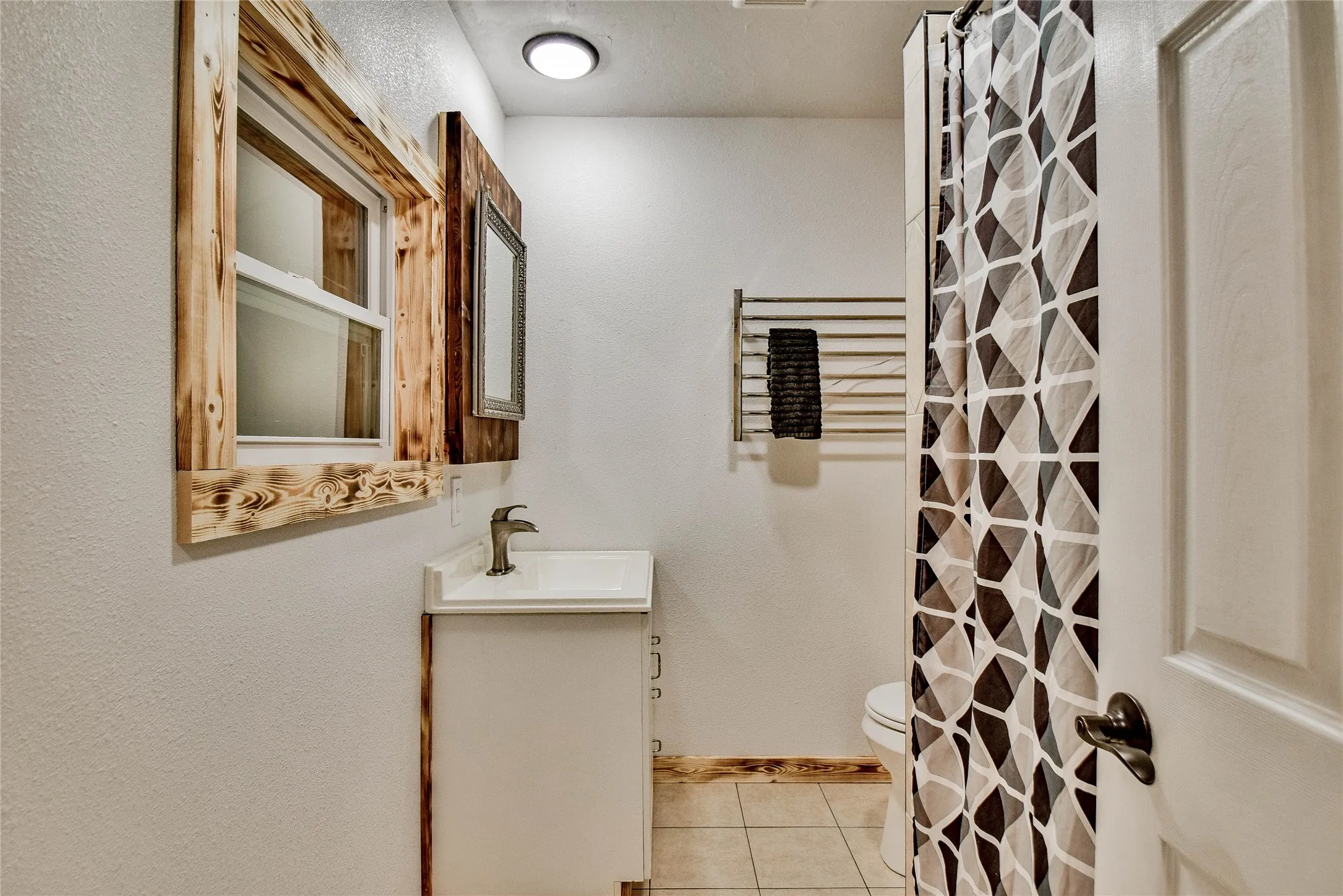 Guest Bathroom featuring ceramic tile flooring, shower and tub combo, and vanity.