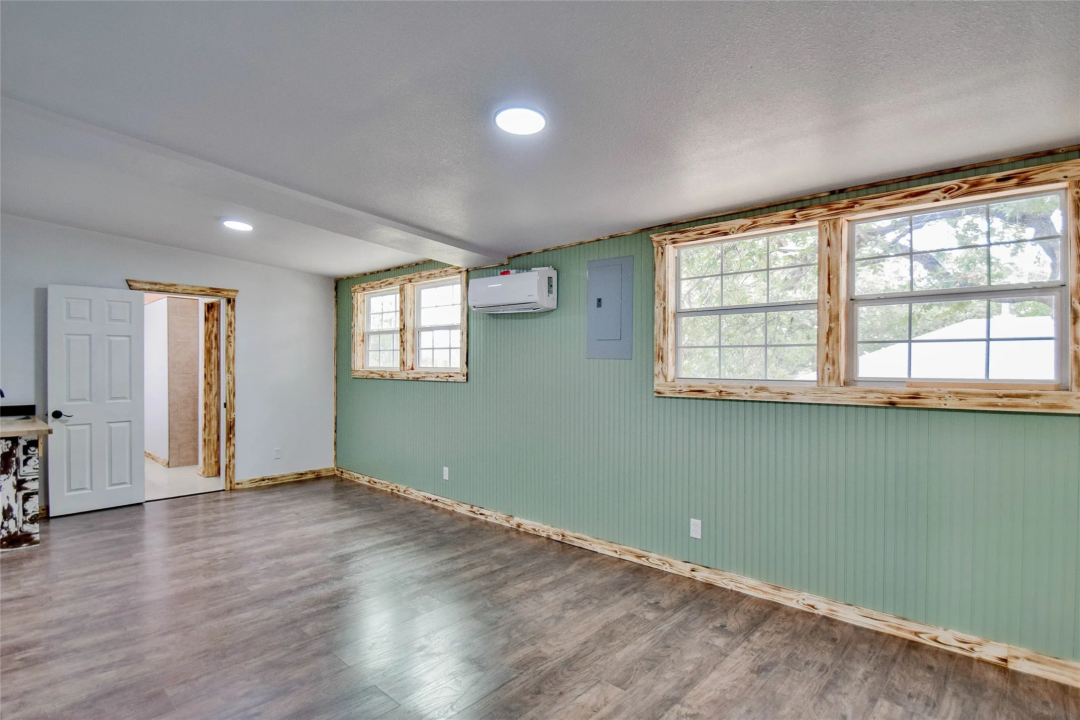 Beautiful Primary bedroom with wood-look laminate floors and a healthy amount of sunlight.