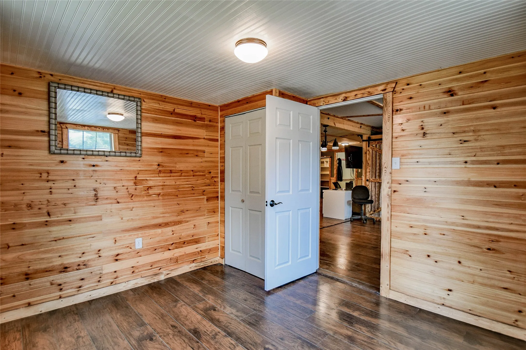 Second guest bedroom provides a cabin feel with all wood paneled walls, B board ceiling and laminate flooring all through the house.