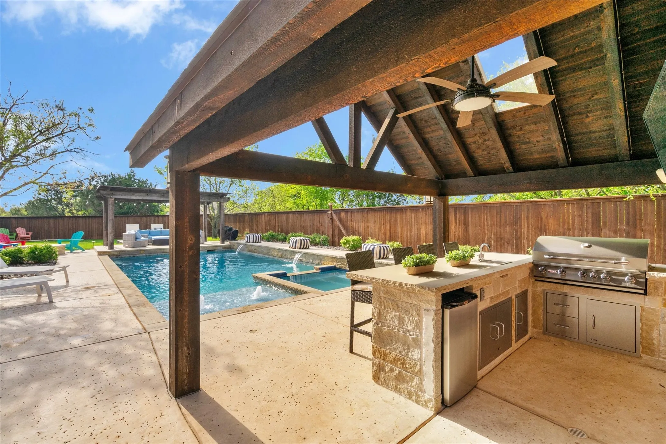 cocered outdoor kitchen with propane grill-sink-refrigerator & fan