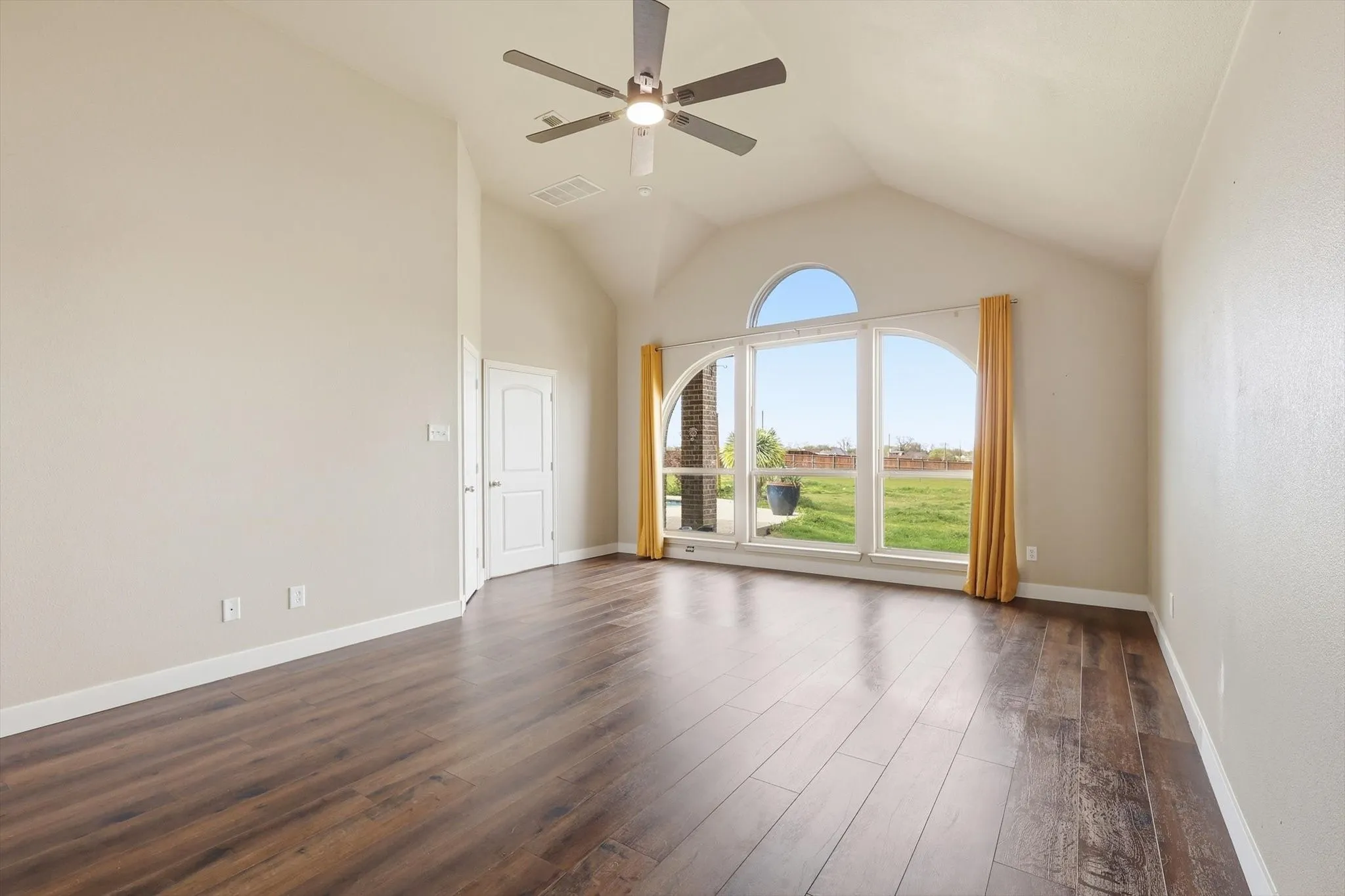Large primary bedroom with natural light, high ceilings, lvp flooring, ensuite bathroom and walk in closet