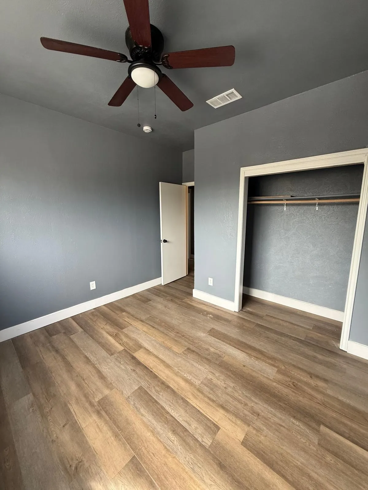 Unfurnished bedroom featuring light wood finished floors, ceiling fan, and a closet