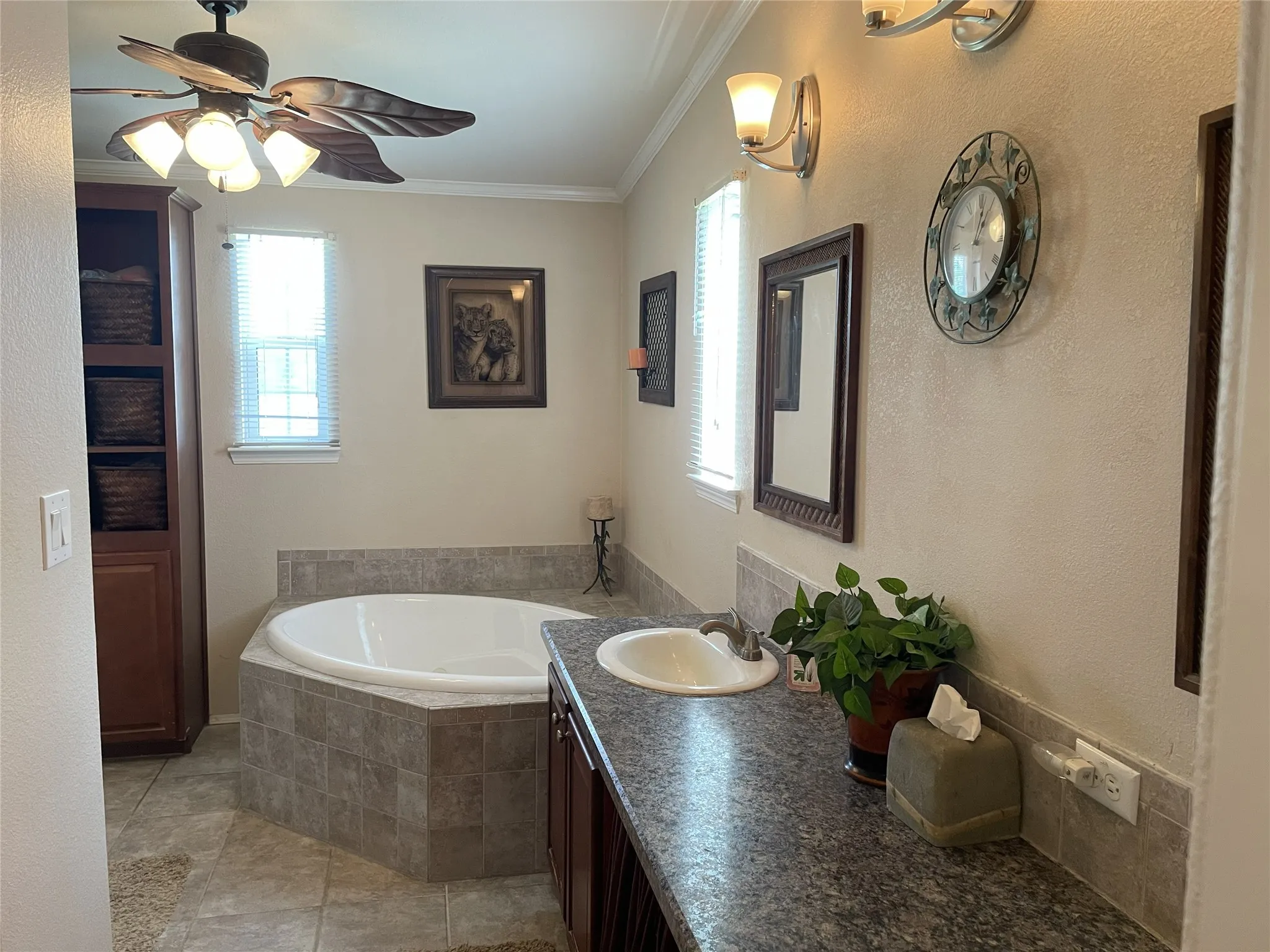 Primary bathroom features a jetted tub, double vanity, linen closet & separate tiled shower