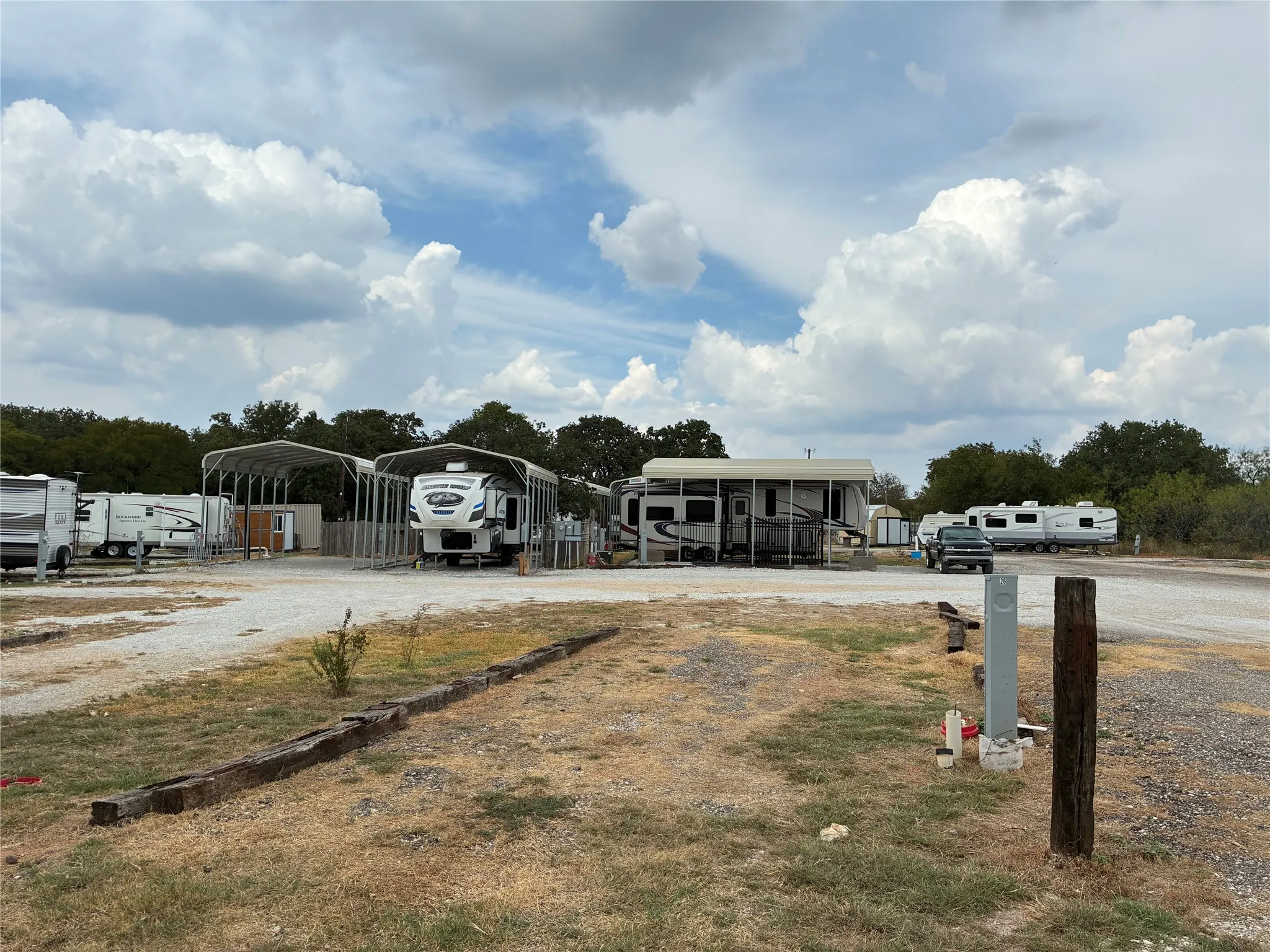 Gravel driveways with utility hookups and metal carports