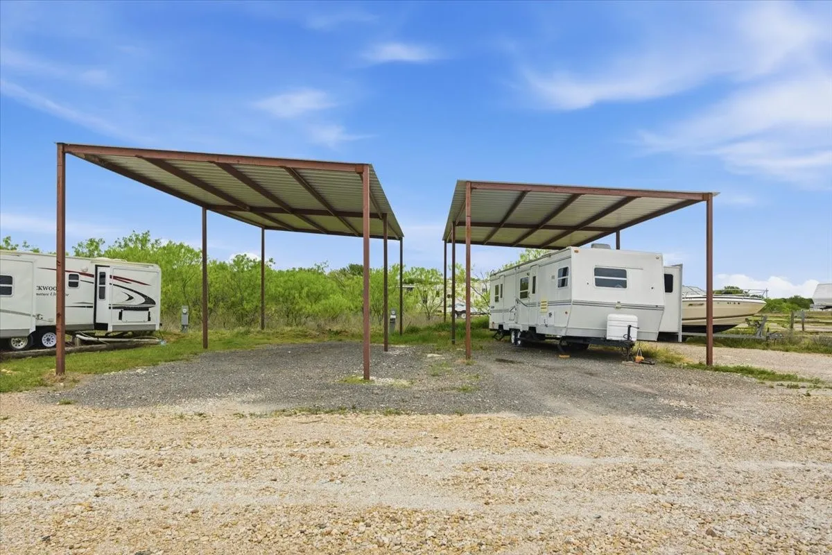 View of parking with a carport and gravel driveway
