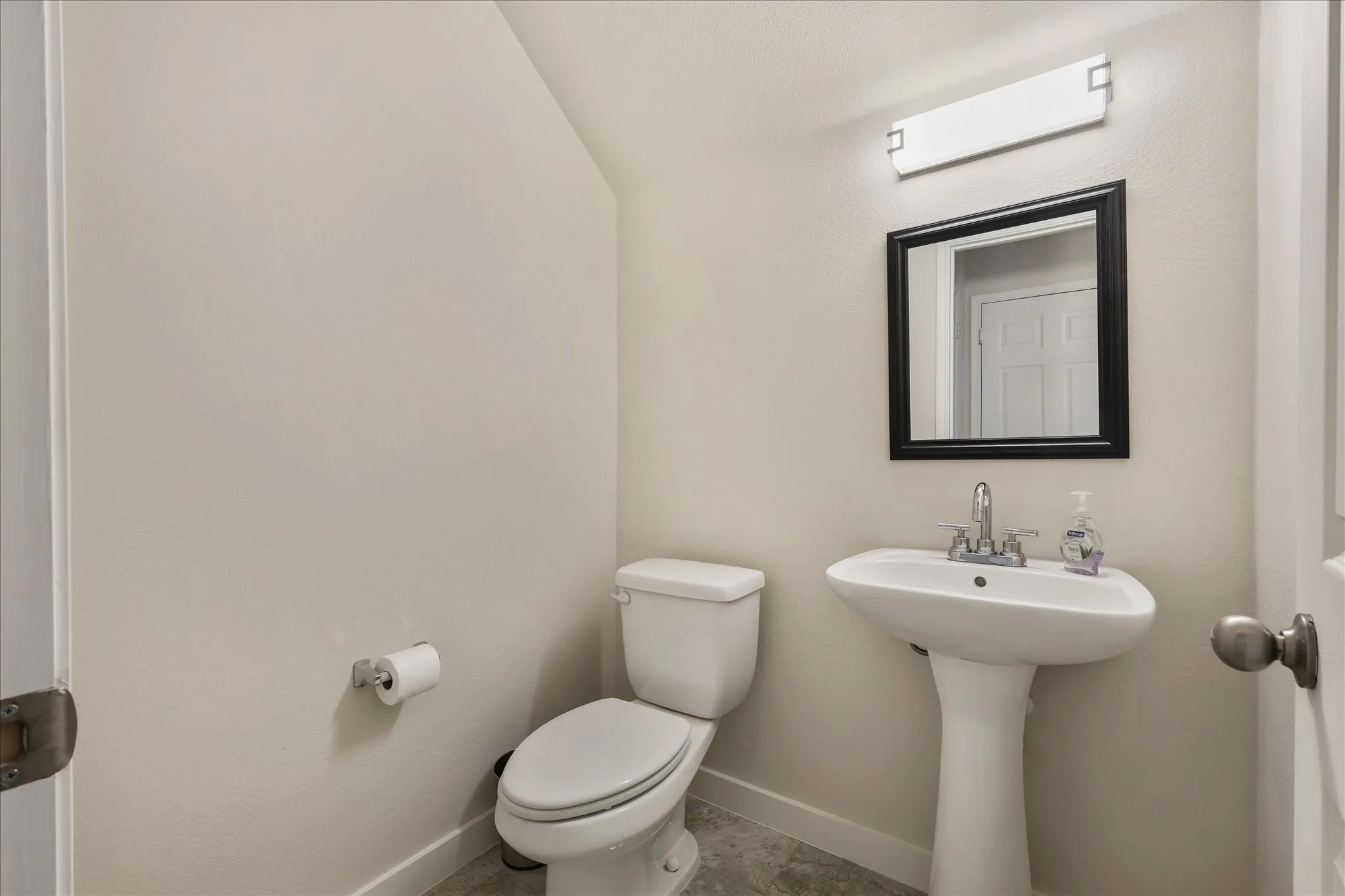 Half bath featuring toilet and lofted ceiling