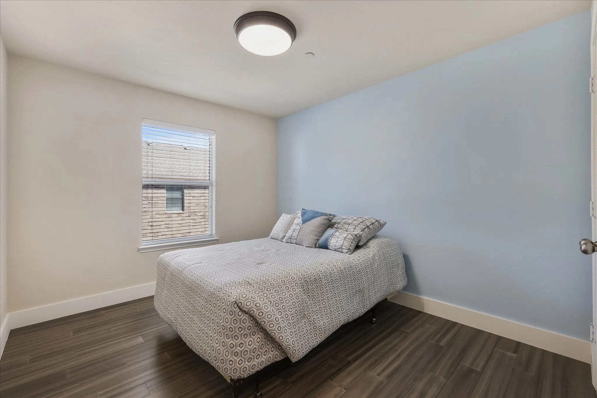 Bedroom featuring dark wood finished floors and baseboards