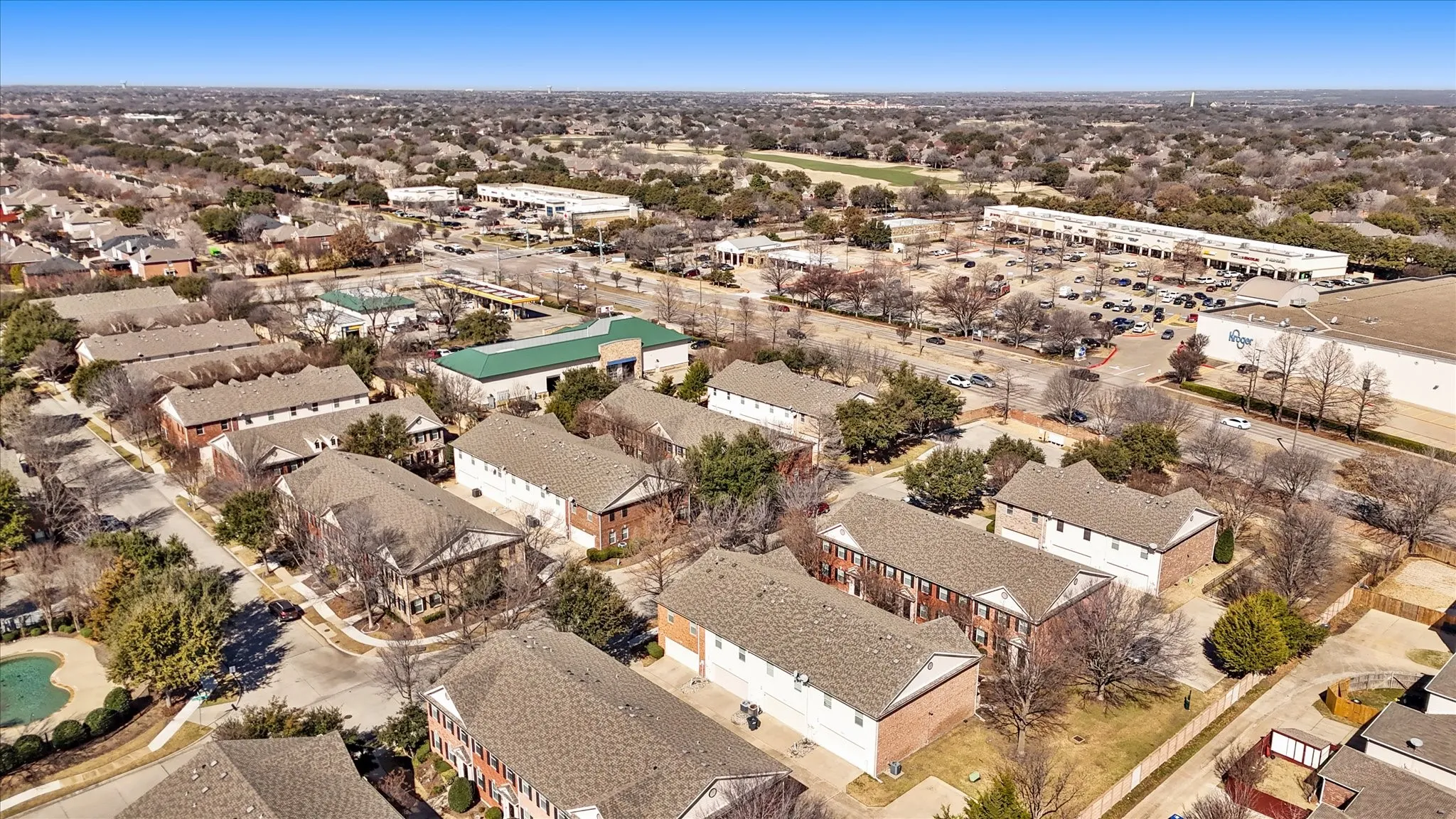 Aerial view of property and surrounding area with nearby suburban area