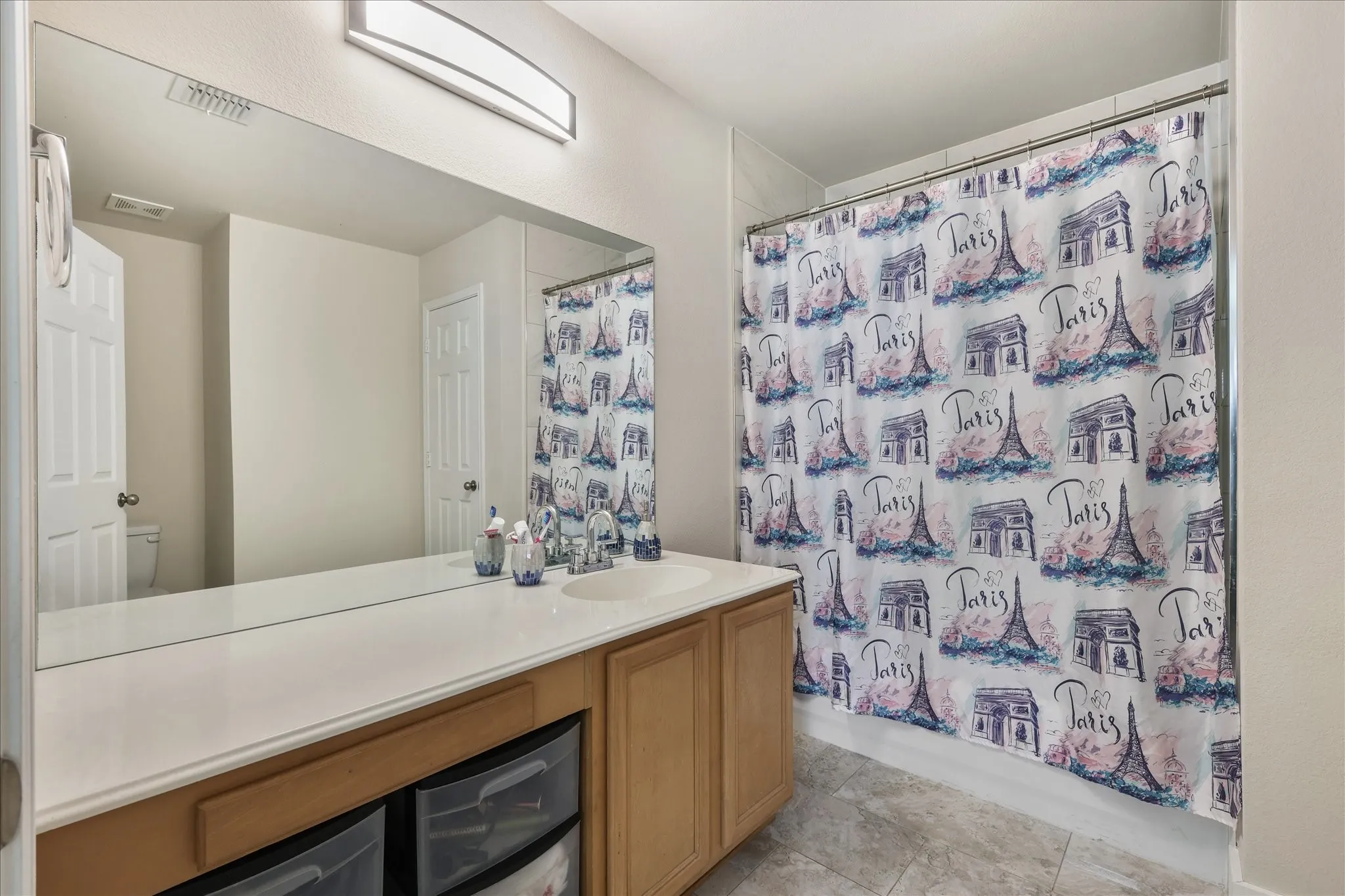 Full bathroom featuring vanity, shower / bath combination with curtain, and light tile patterned flooring