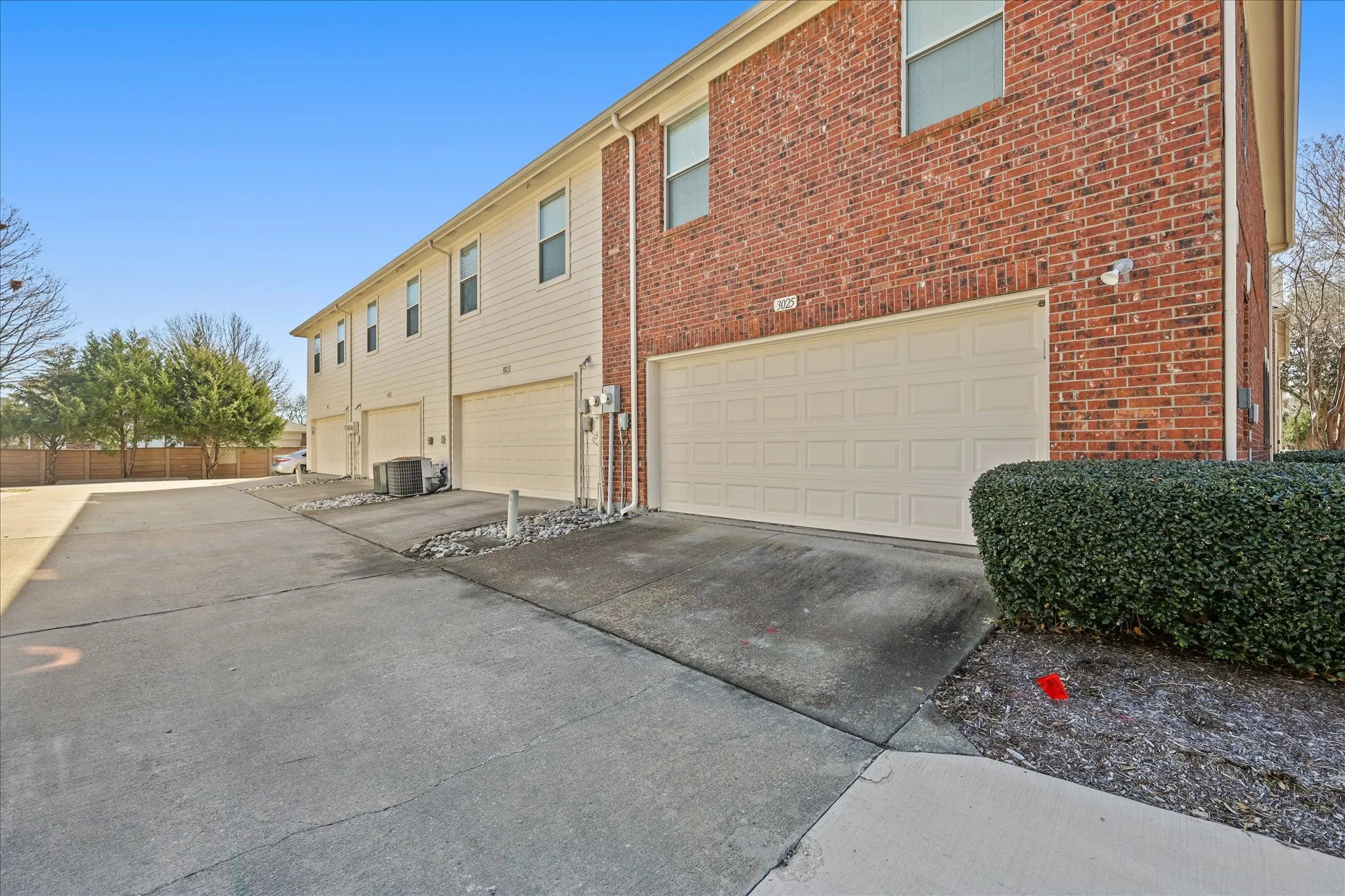 View of side of home with a garage, driveway, and brick siding