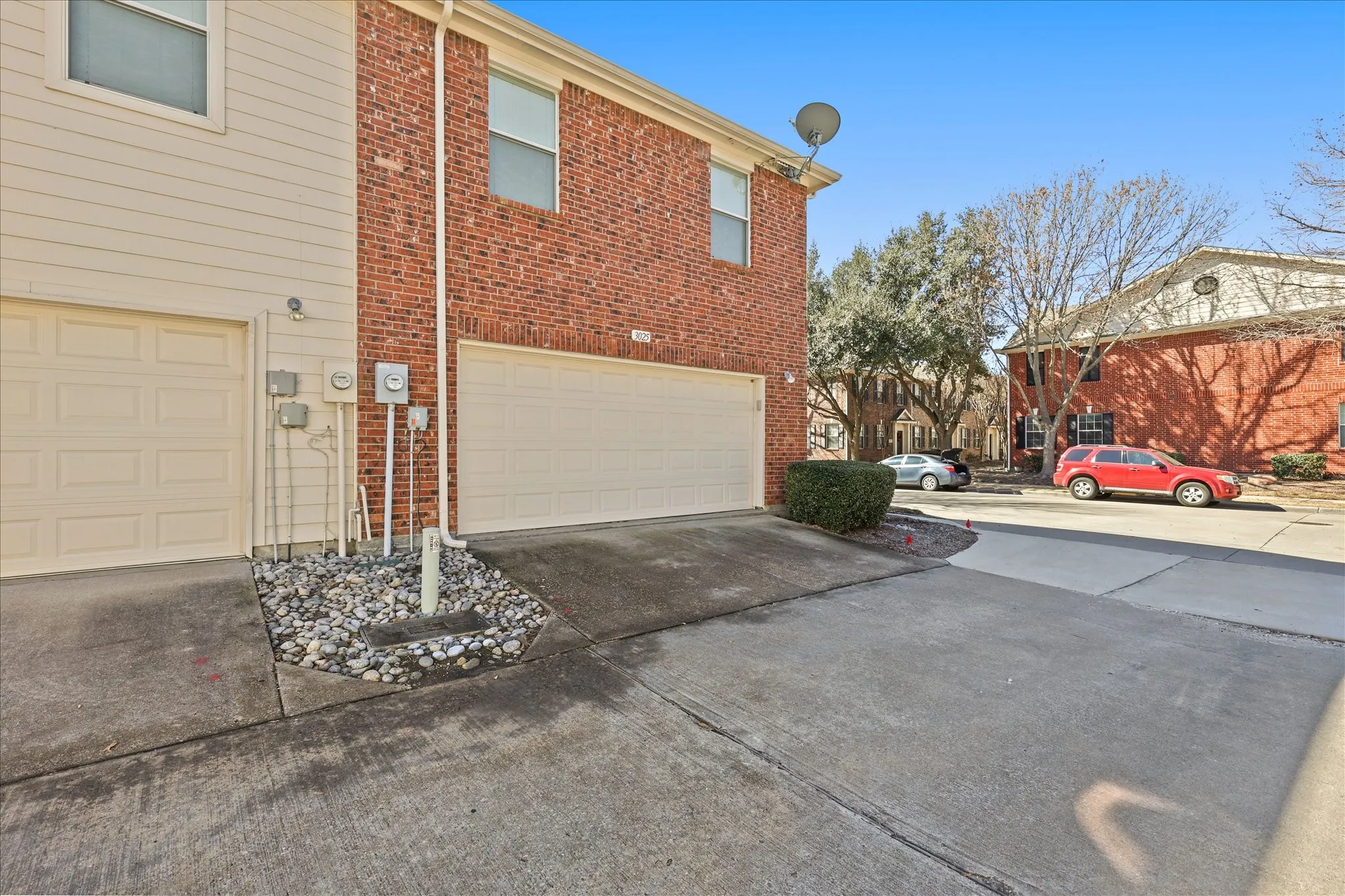 View of home's exterior with an attached garage, concrete driveway, and brick siding