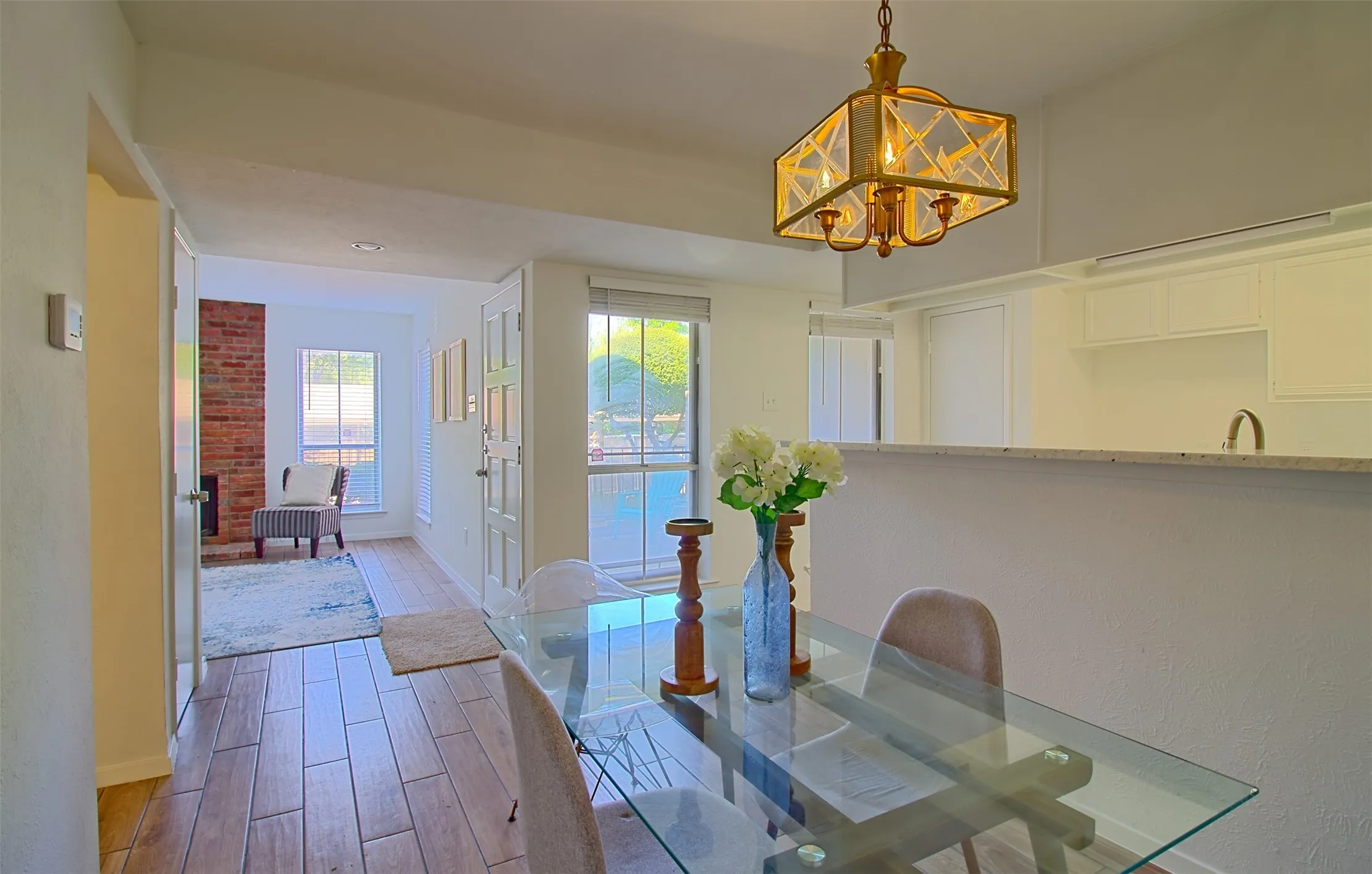 Dining area with light wood-style flooring and suspended lighting