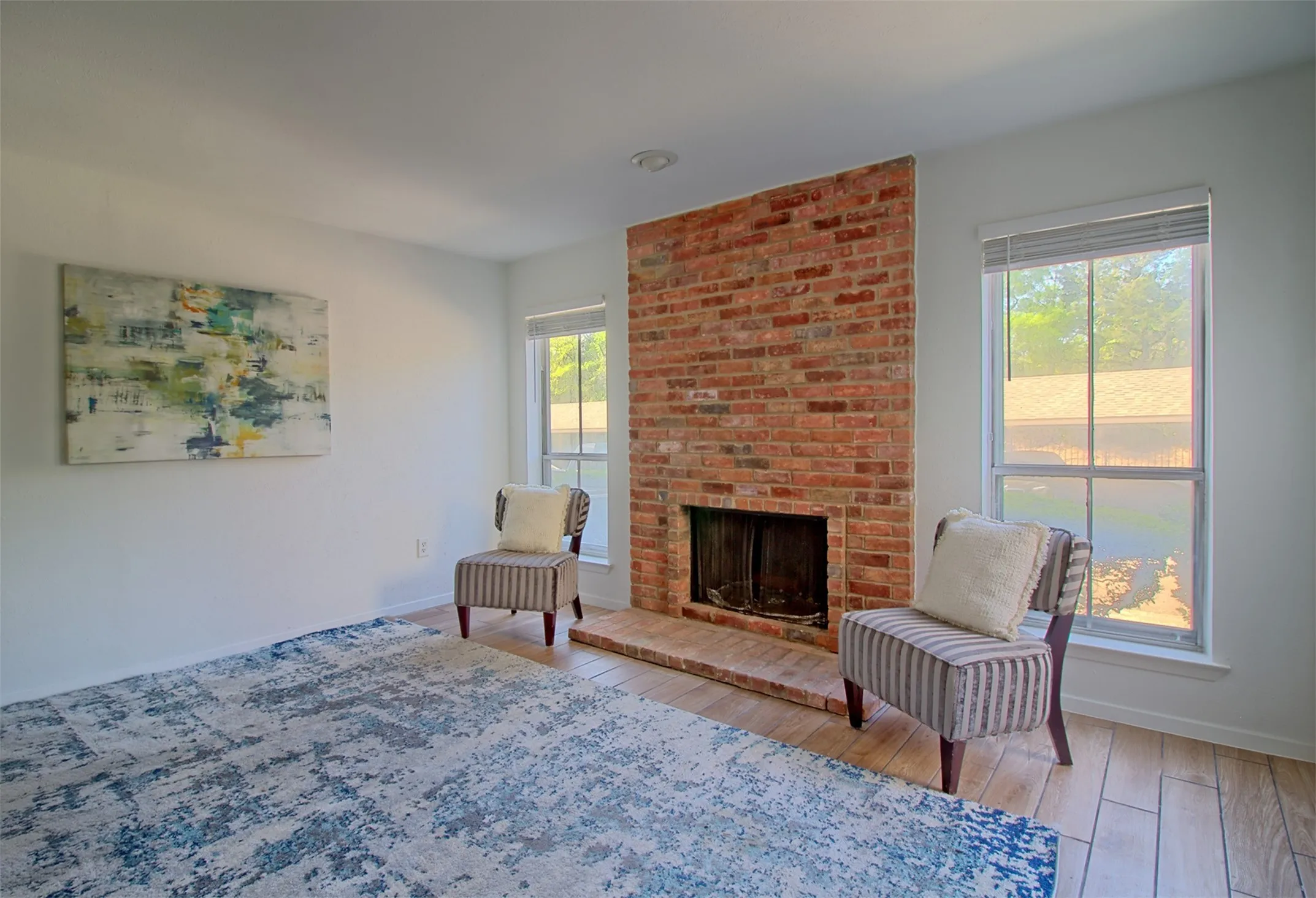 Living area with light wood-type flooring and a fireplace