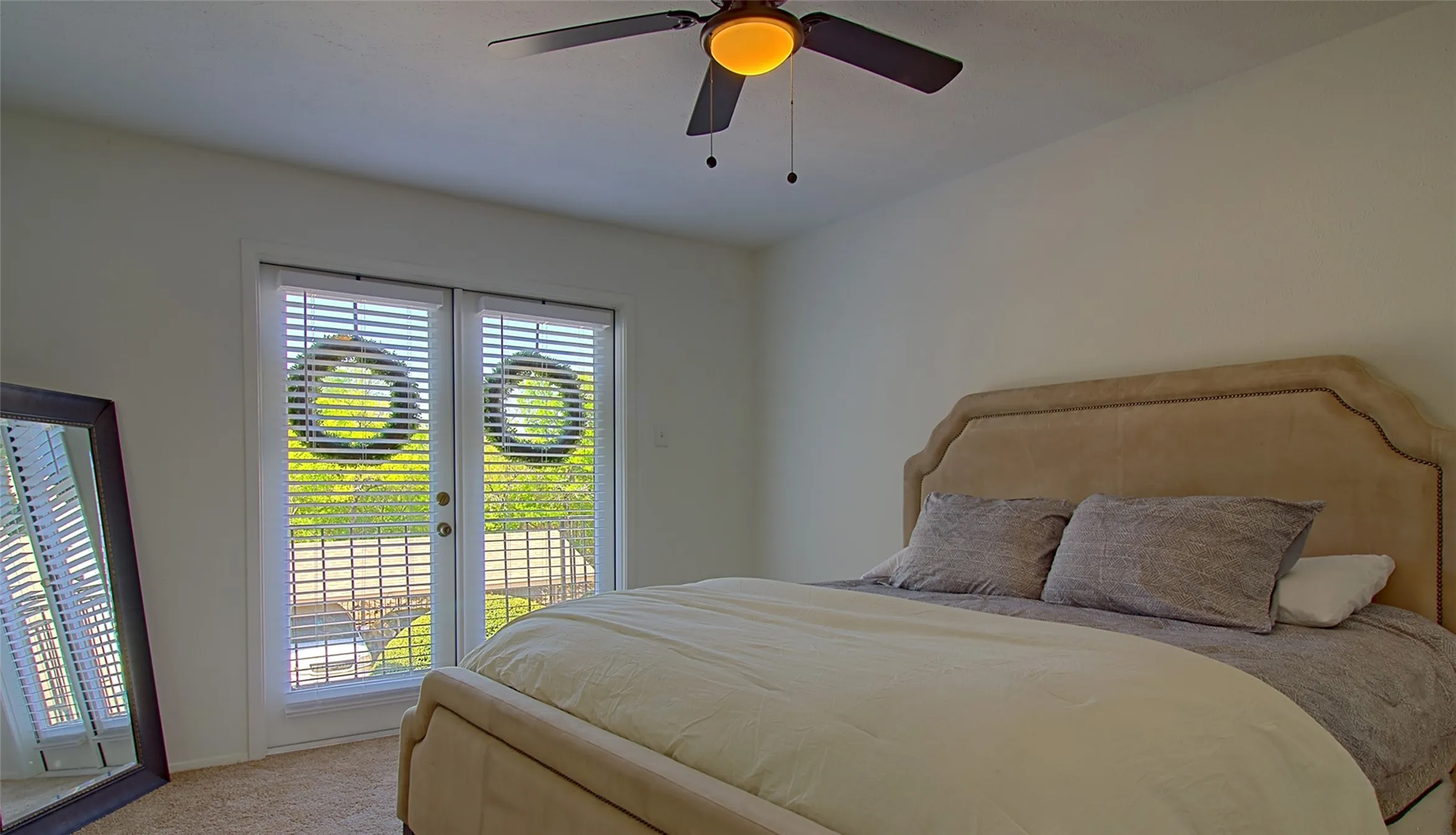 Carpeted bedroom featuring access to outside, ceiling fan, and french doors