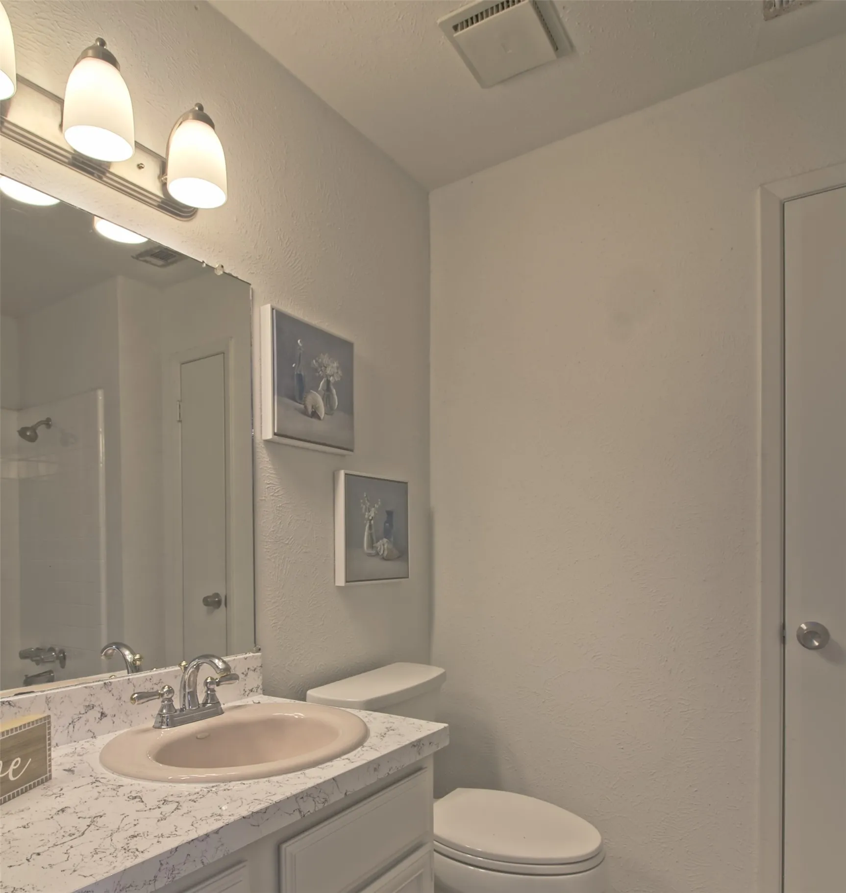 Bathroom with a textured wall and vanity