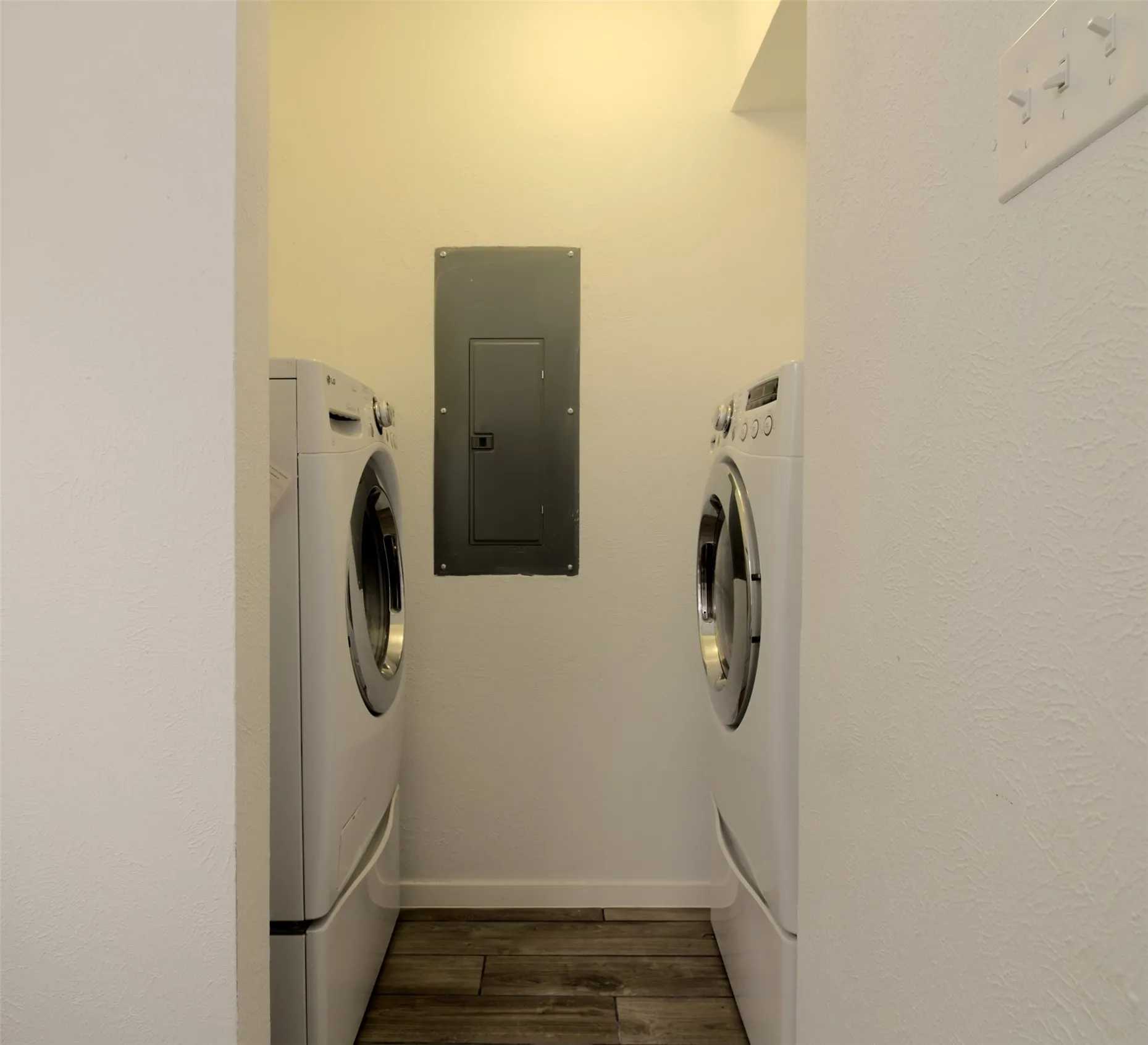 Laundry area featuring electric panel, dark wood-style floors, and washer and clothes dryer