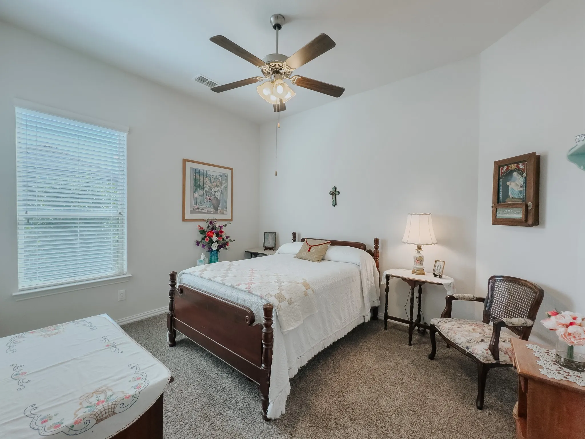 Bedroom on first floor with ceiling fan and light carpet