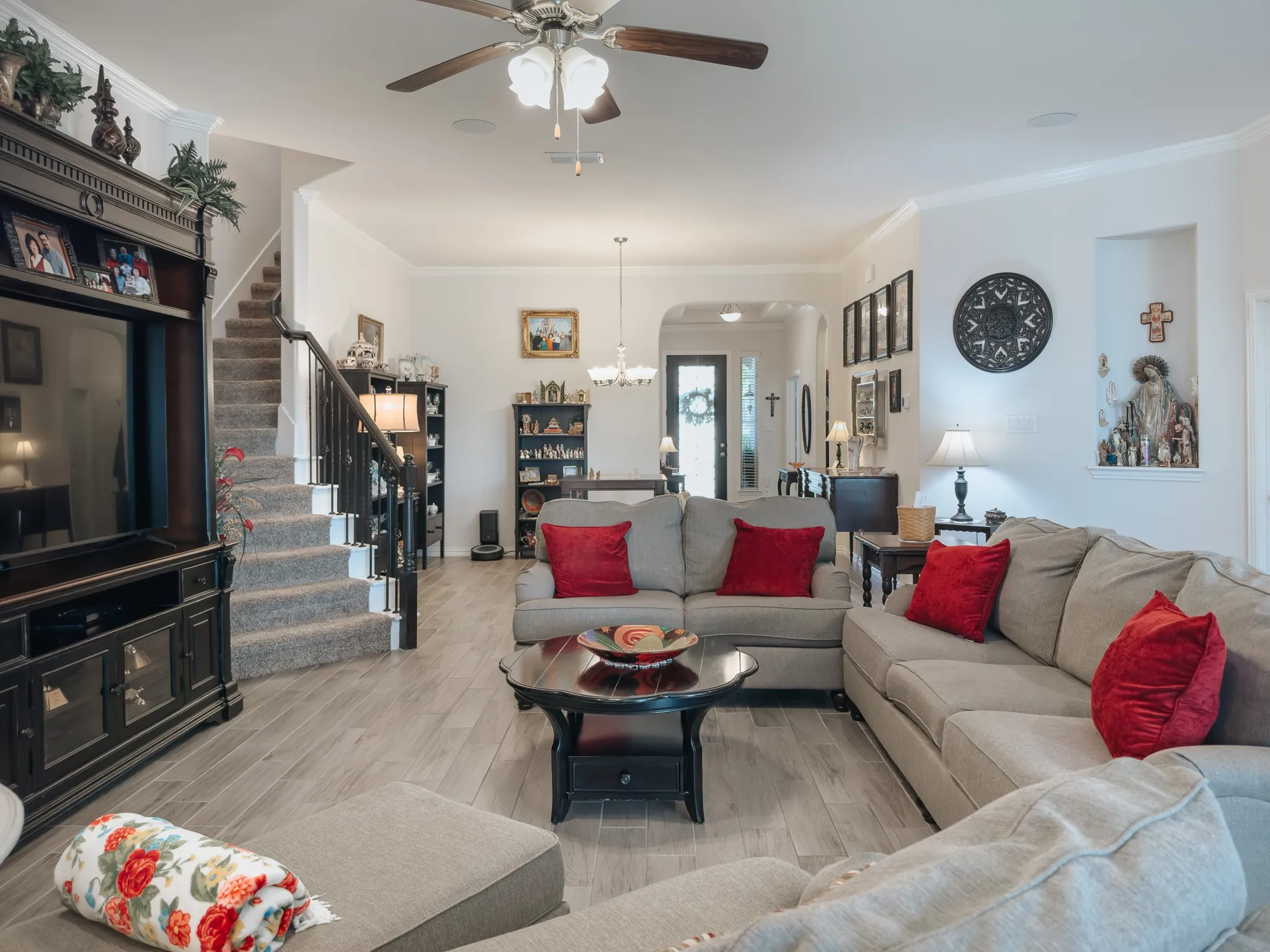 Living room with, ornamental molding, and ceiling fan with notable chandelier