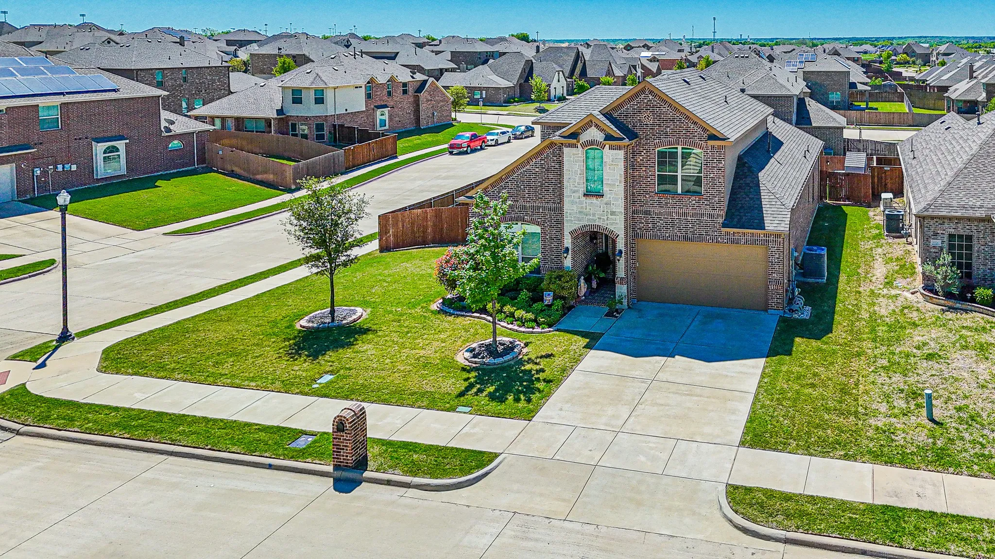View of front of home with corner lot, a front yard, and a garage with sprinkler system
