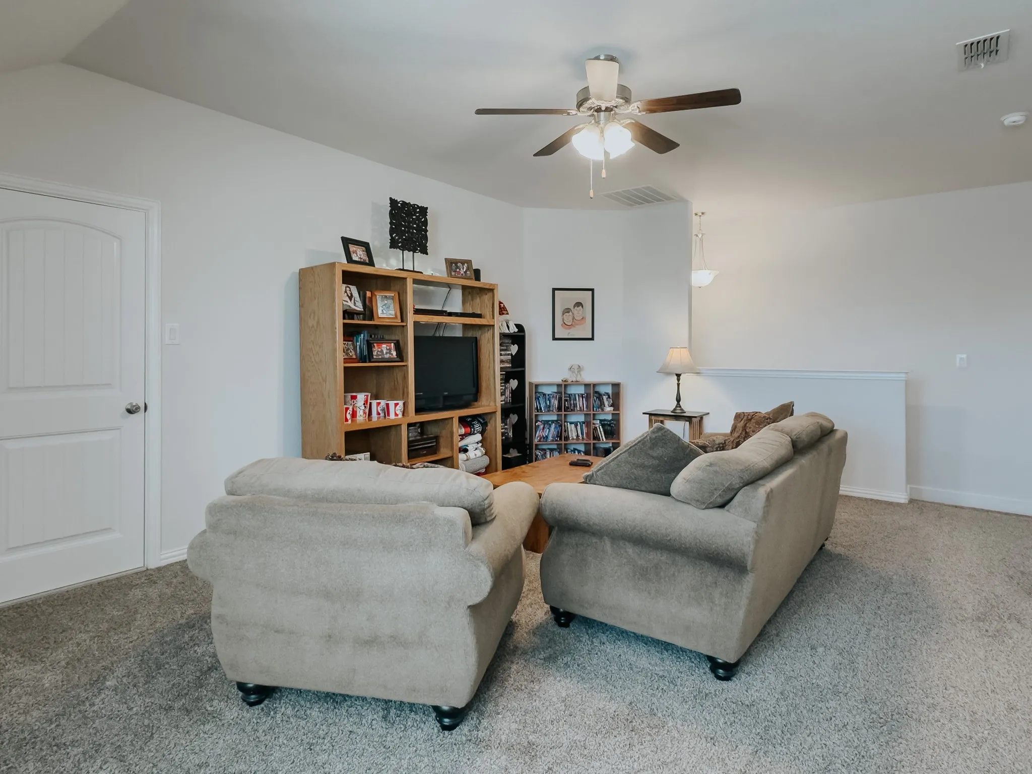 Carpeted upstairs loft featuring lofted ceiling and ceiling fan-- or extra family living area or gameroom or another office.