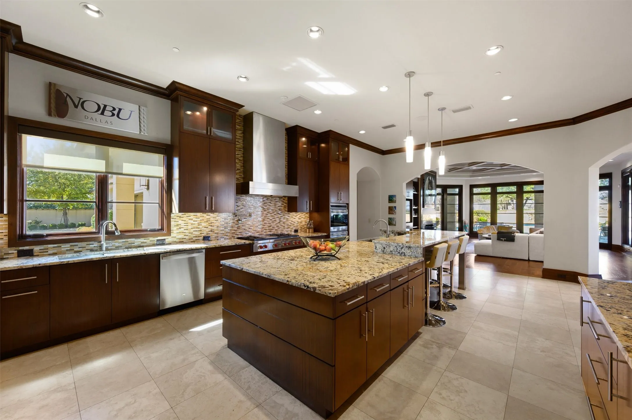 Kitchen featuring glass insert cabinets, a breakfast bar, Granite counters, and dark wood finish cabinets