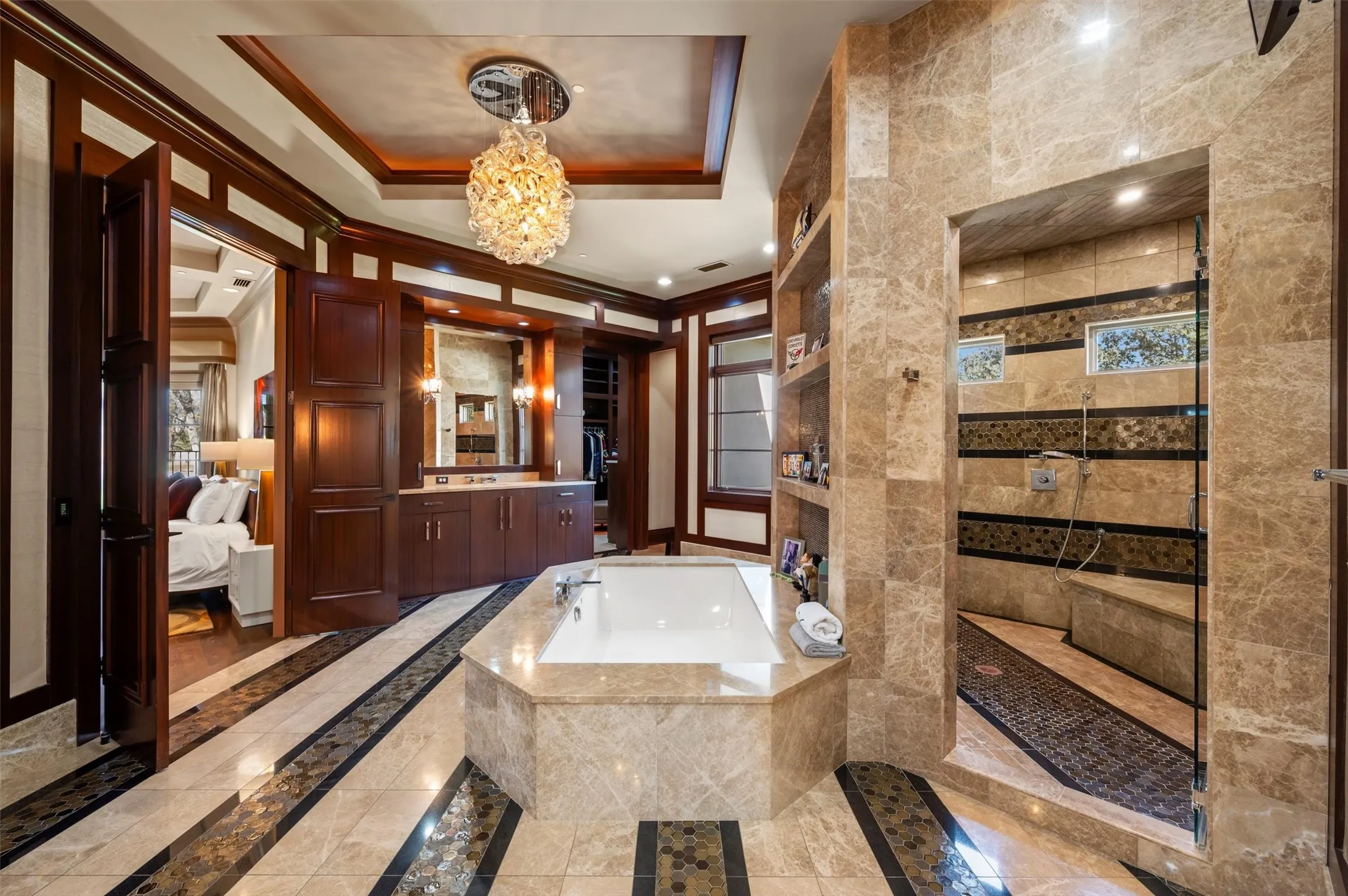 Primary Ensuite bathroom, walk-in shower with dual shower sprayer, his and her toilet rooms, and large his and her custom walk-in closets