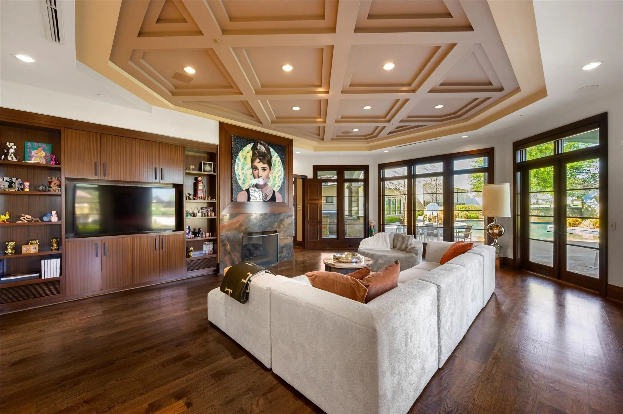 Living area featuring coffered ceiling, recessed lighting, dark wood-style flooring, a fireplace, and built in shelves