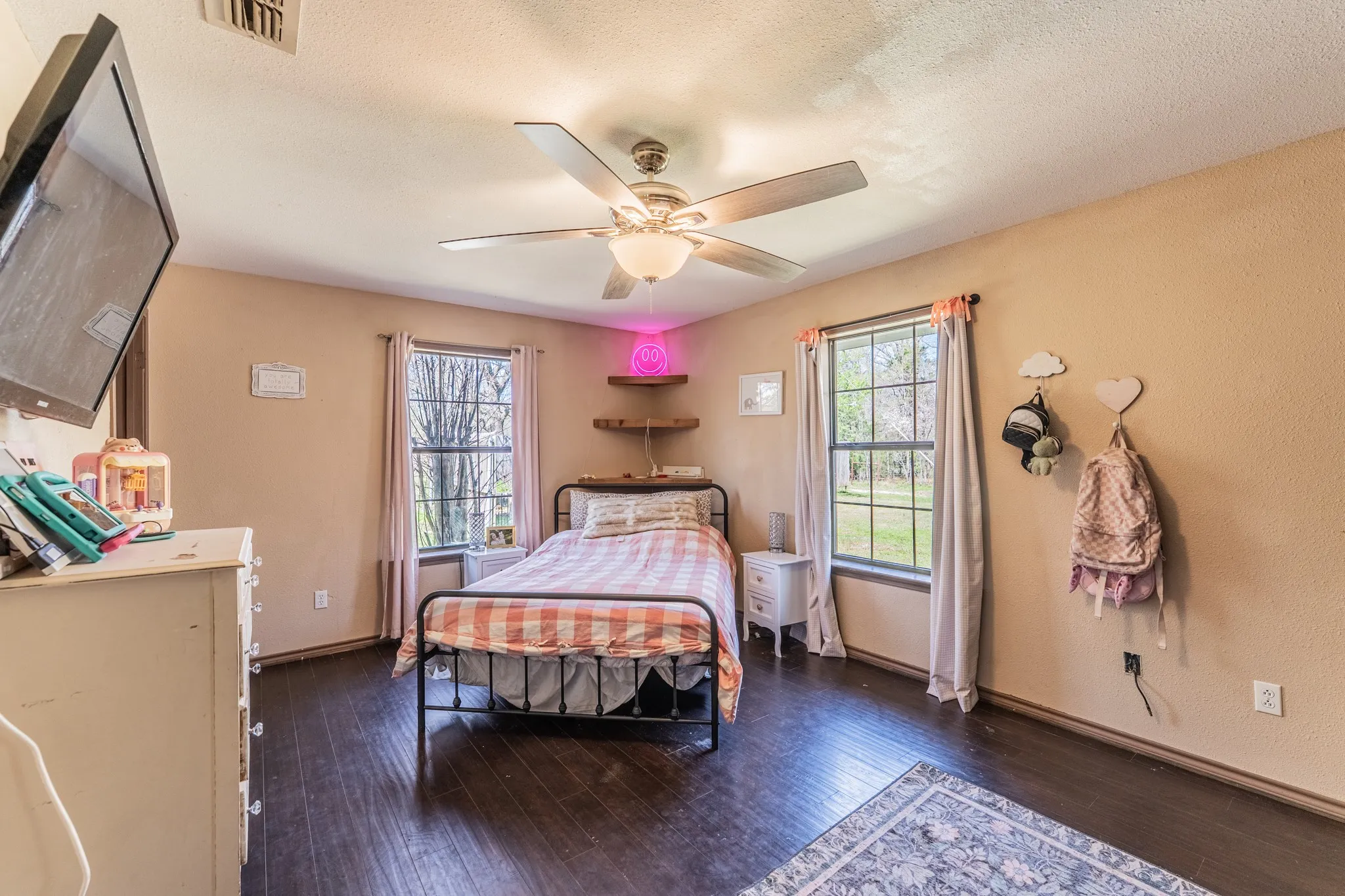 Bedroom with dark wood-style flooring, ceiling fan, and a textured ceiling
