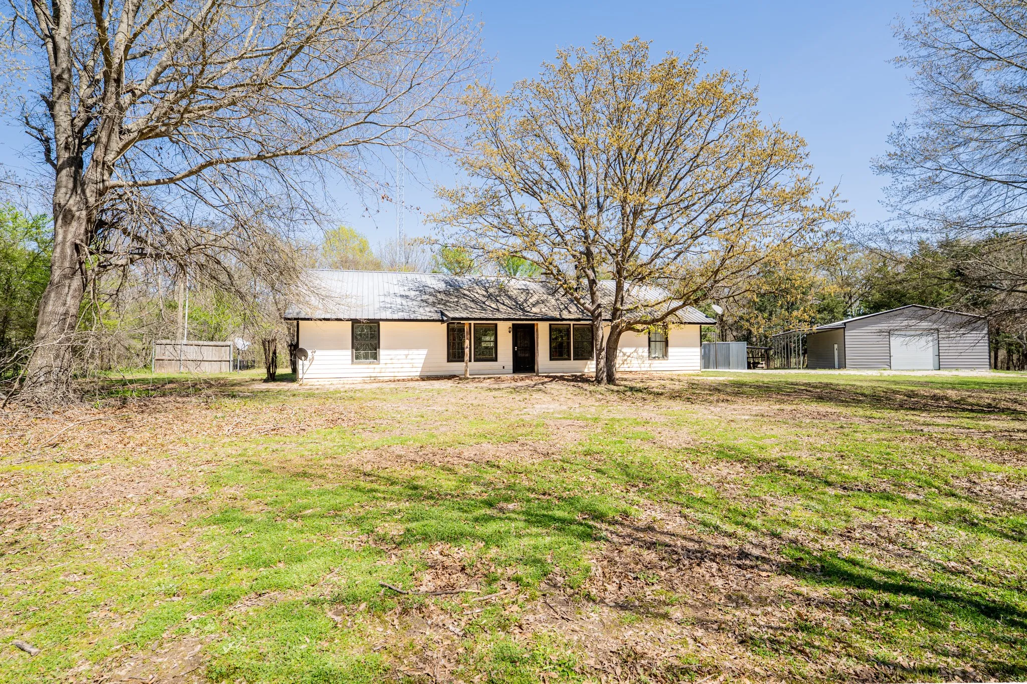 Rear view of property featuring a patio area, an outbuilding, and a garage