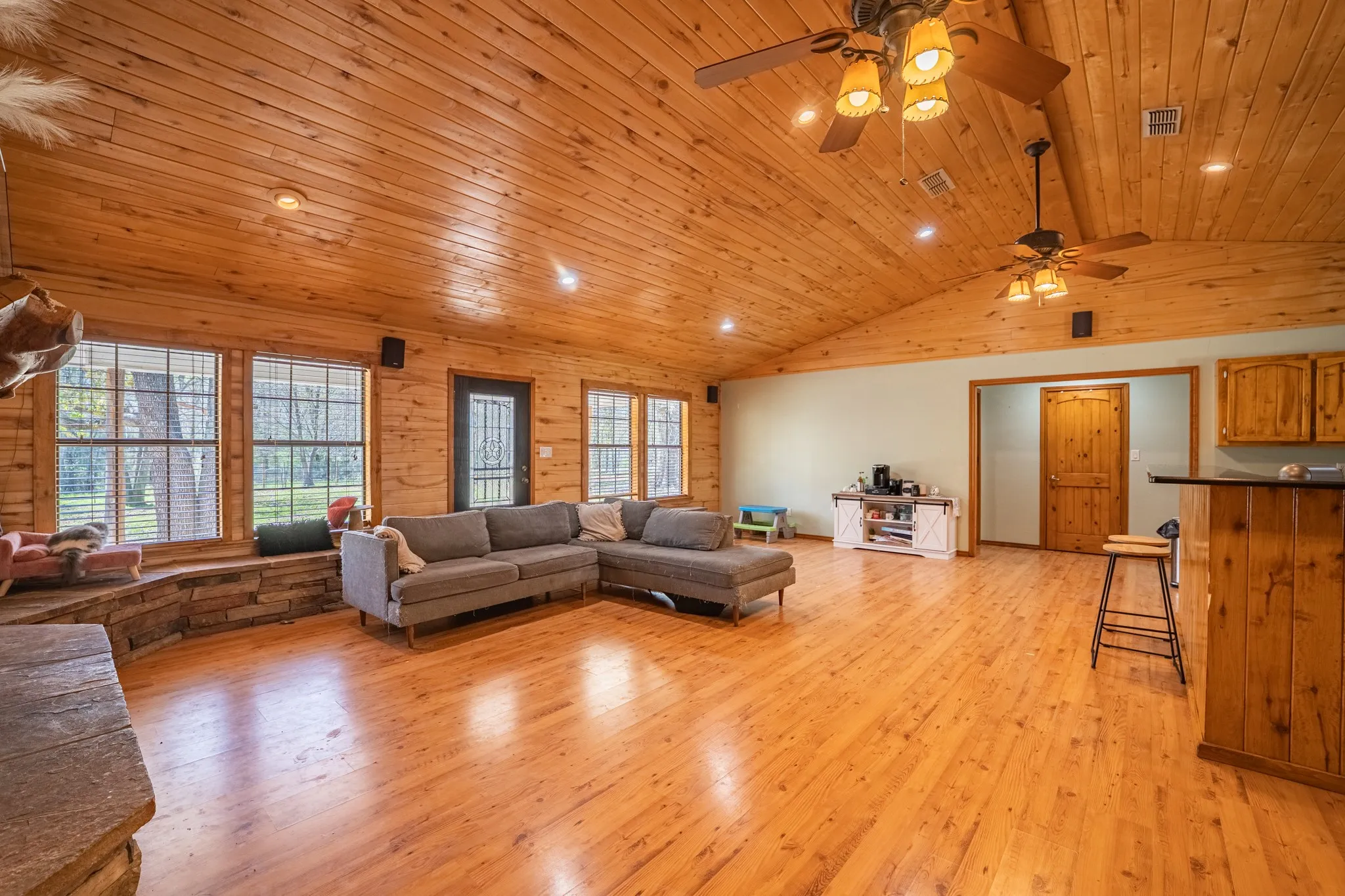 Living room featuring light wood-style flooring, plenty of natural light, ceiling fan, recessed lighting, and a vaulted wood ceiling