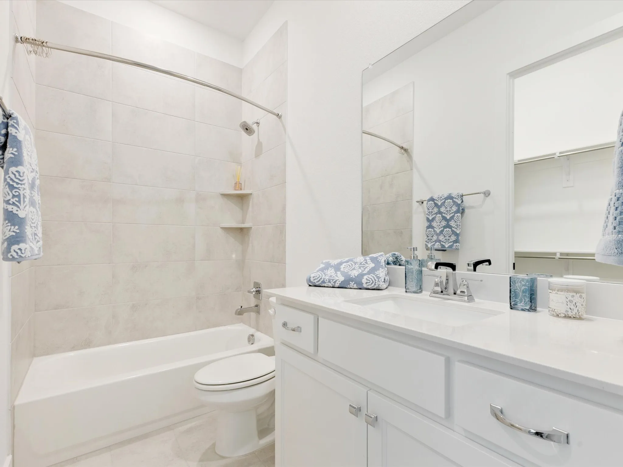 MIL ensuite bathroom featuring vanity, shower / bath combination, and a walk in closet