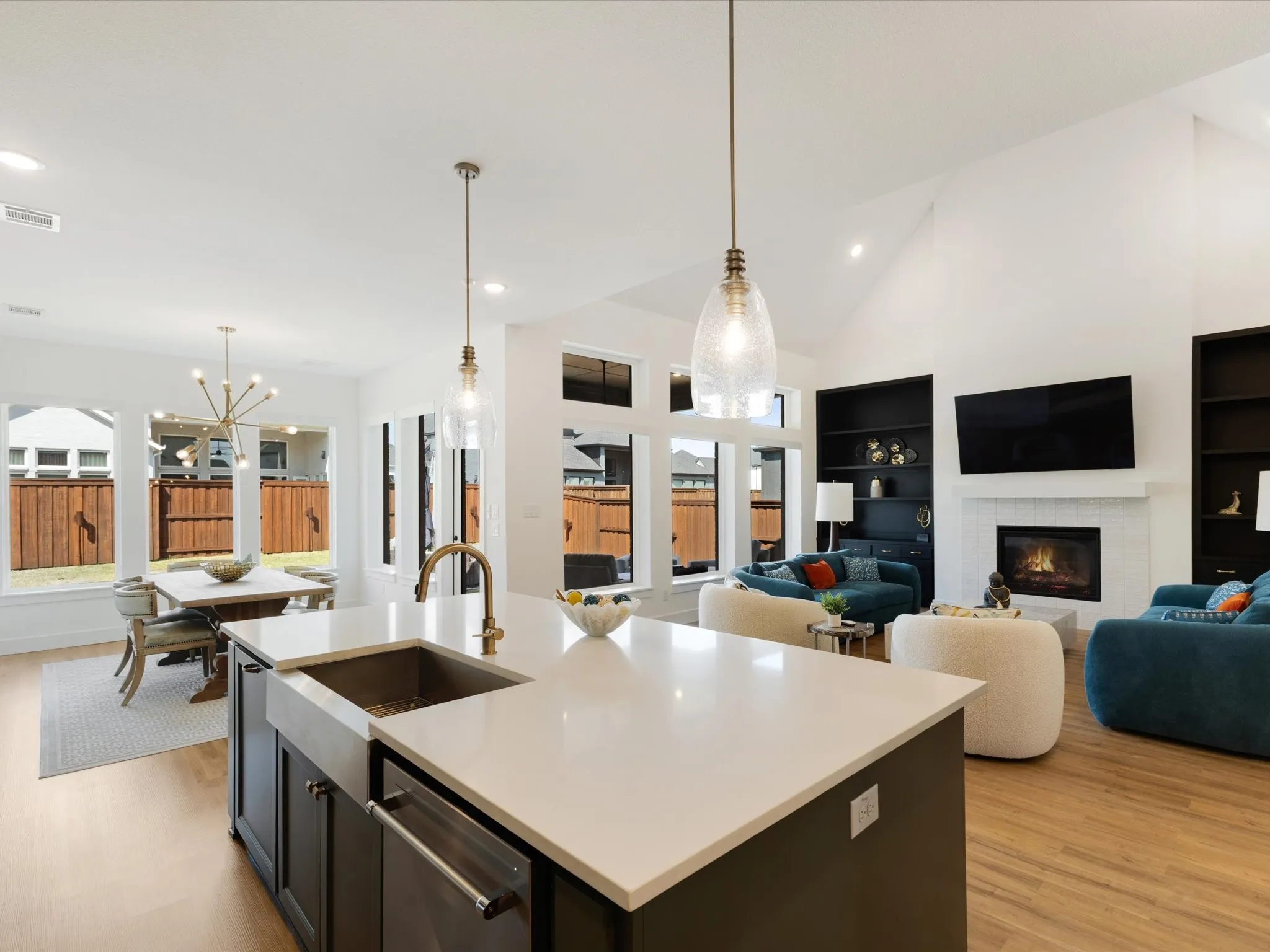 Kitchen featuring a chandelier, light wood-style flooring, open floor plan, a kitchen island with sink, and vaulted ceiling
