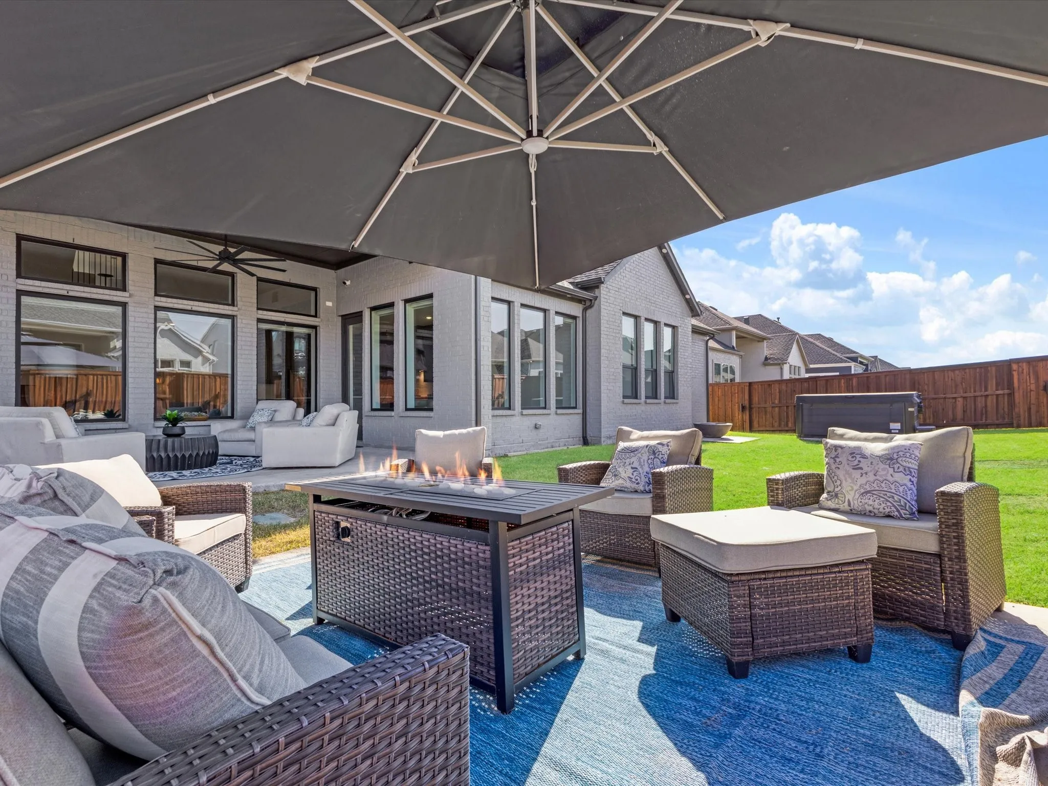 Fenced backyard with outdoor lounge area, a patio area, and a ceiling fan