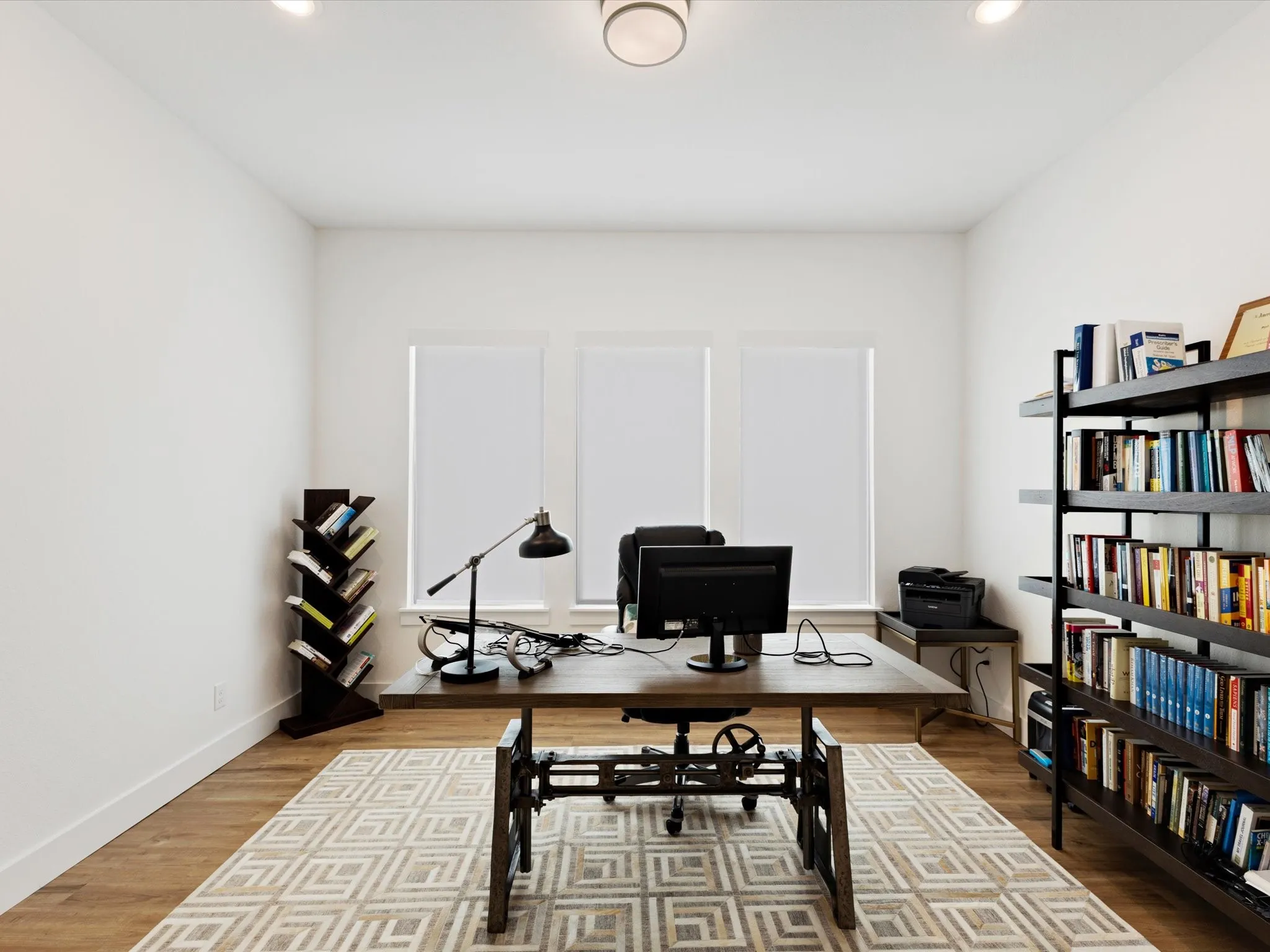 Office with wood finished floors and recessed lighting