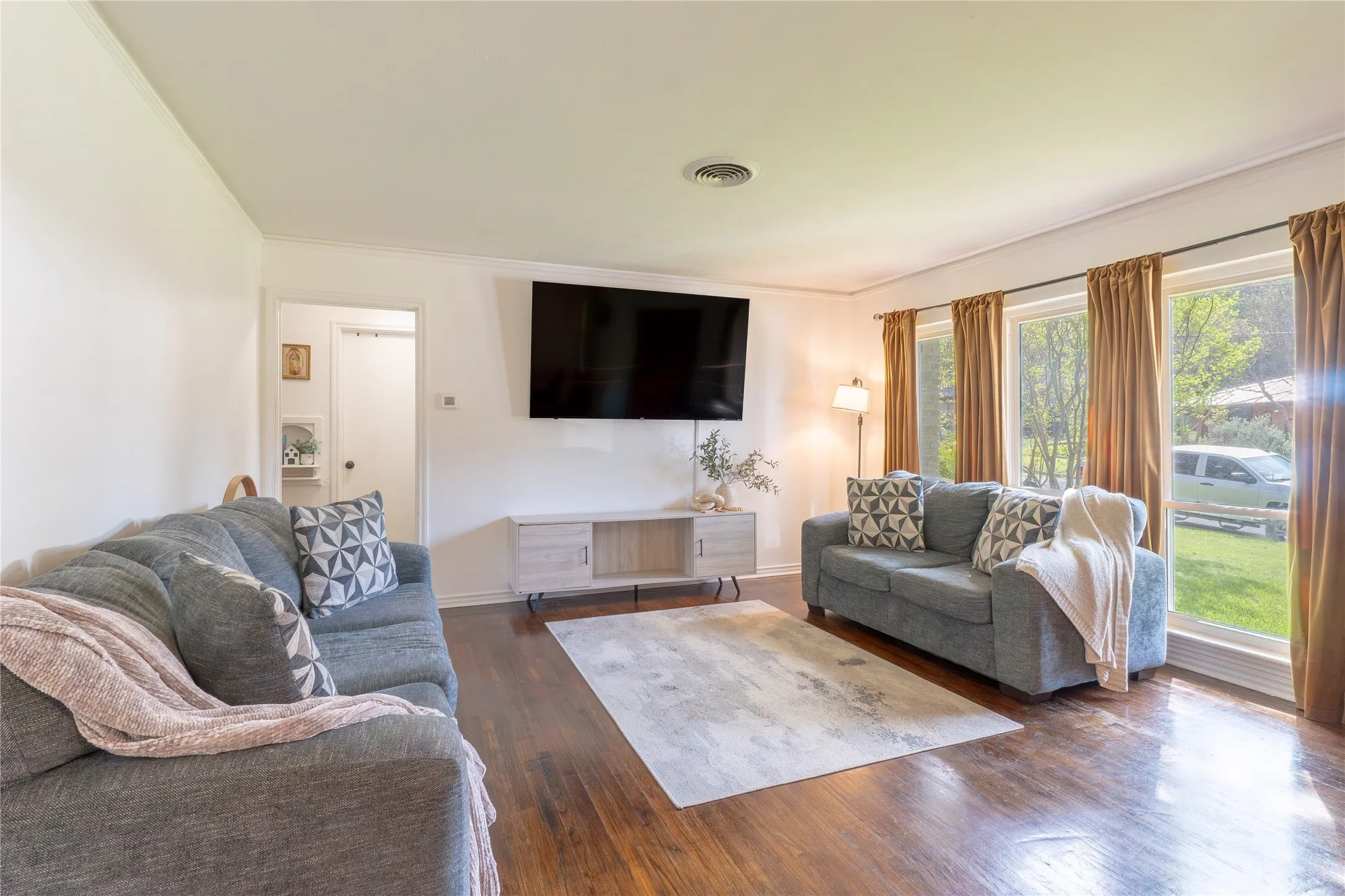 Living area featuring dark wood finished floors and ornamental molding