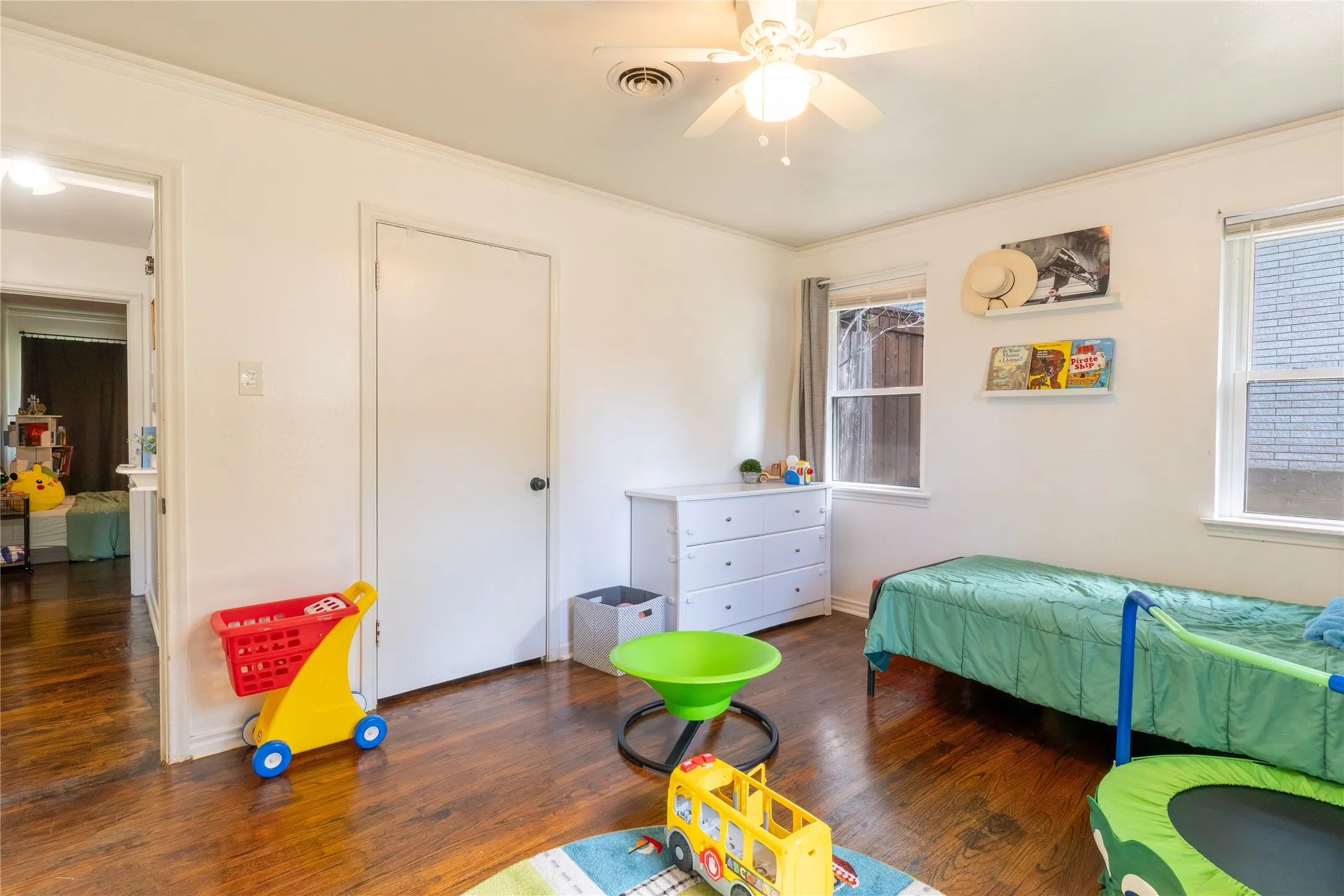 Bedroom with dark wood-style floors, crown molding, and ceiling fan
