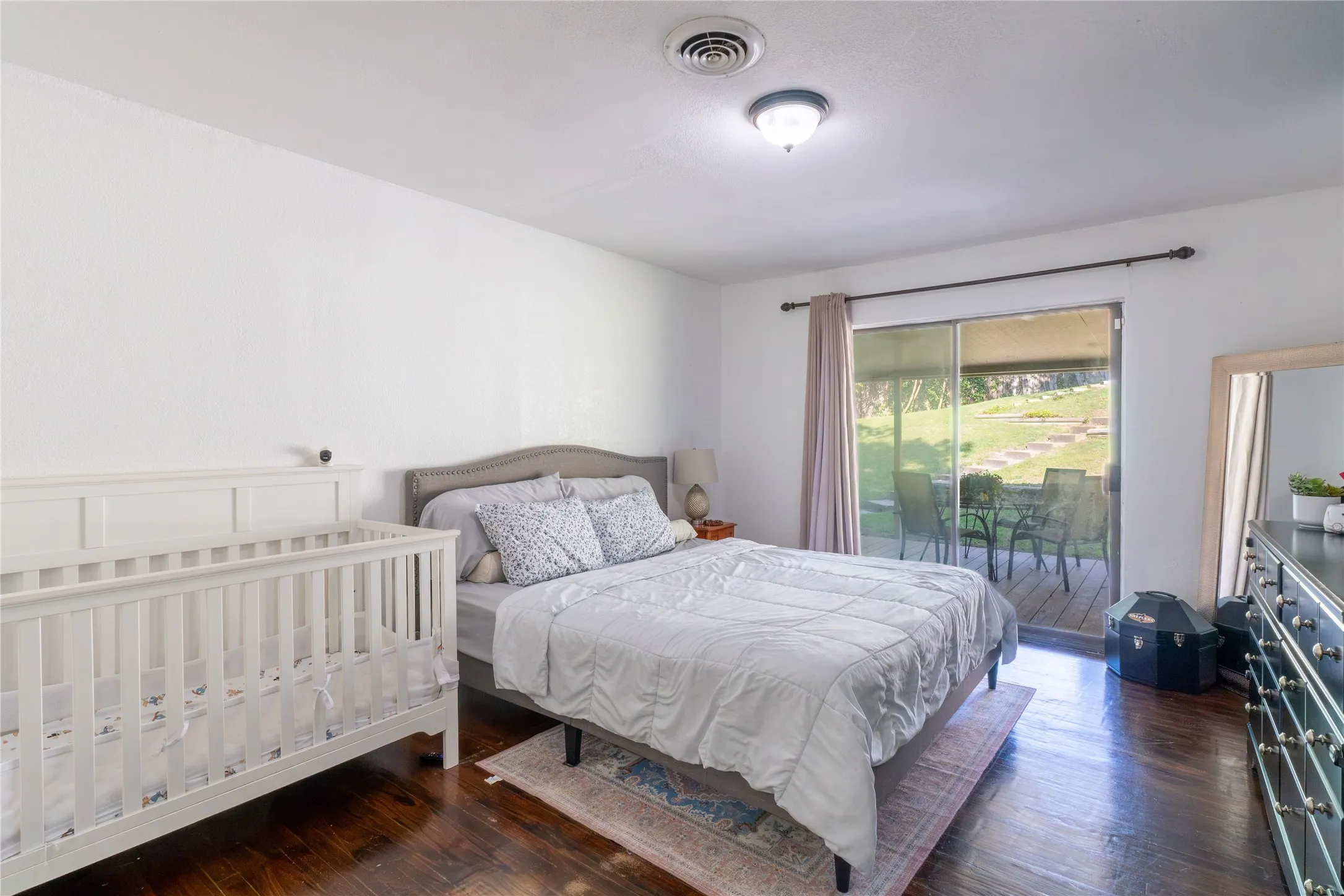 Bedroom with dark wood-style flooring and access to outside