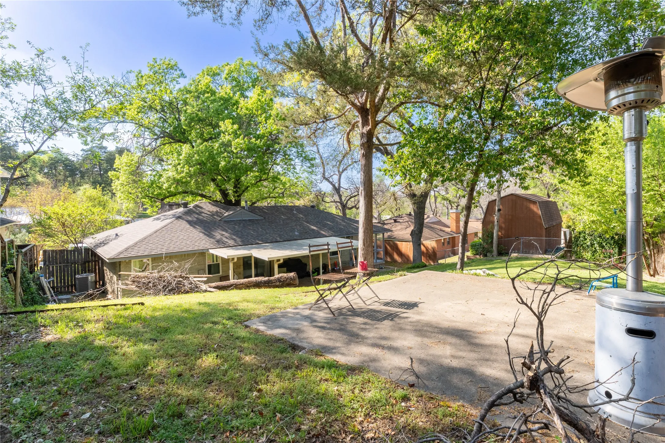 Rear view of house with a fenced backyard, a patio, and view of wooded area