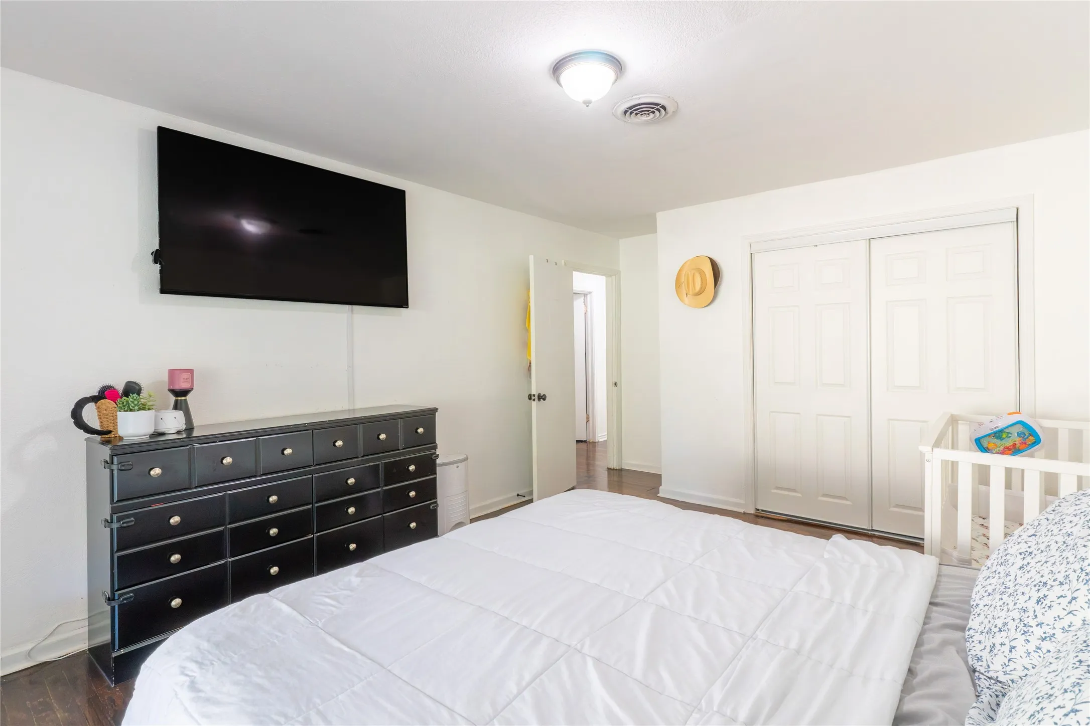 Bedroom featuring dark wood-style floors and a closet