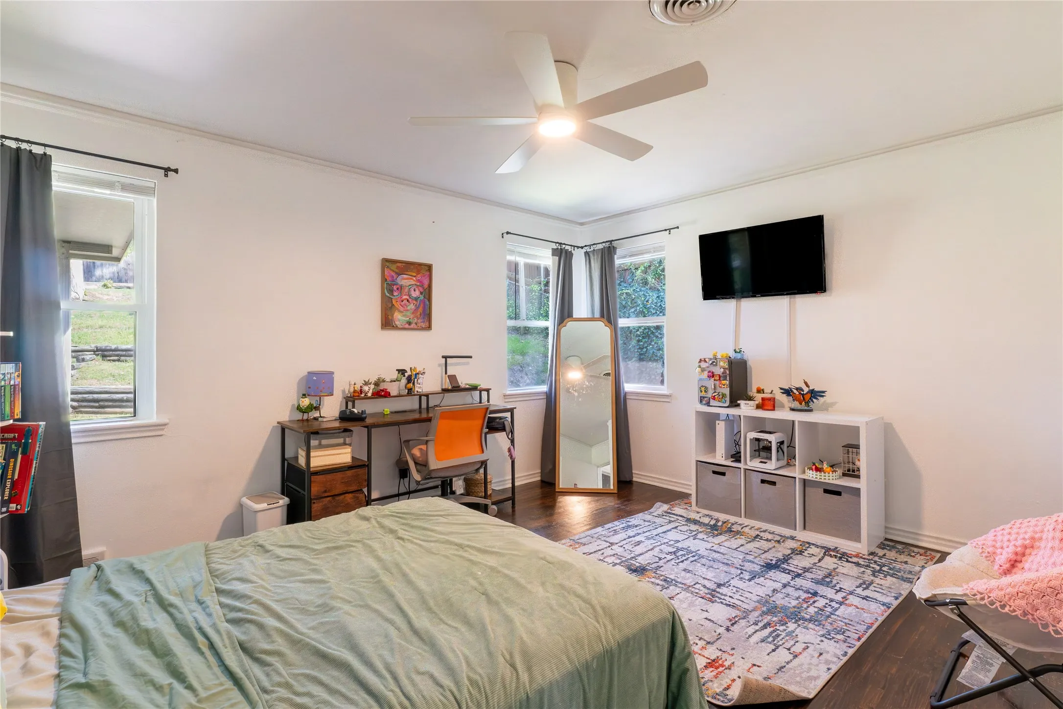 Bedroom featuring dark wood-type flooring, a ceiling fan, and ornamental molding