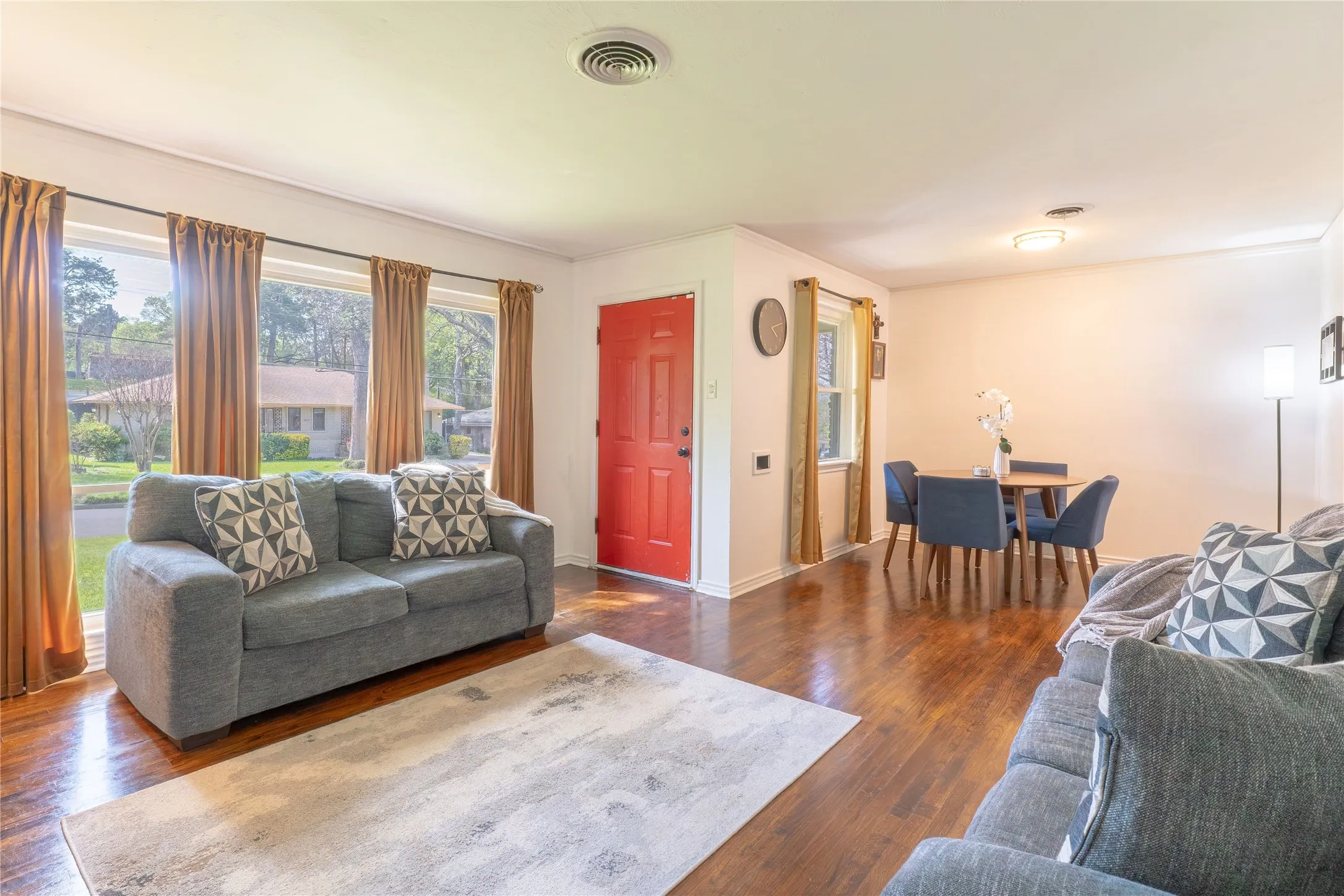 Living room with dark wood-style floors and crown molding