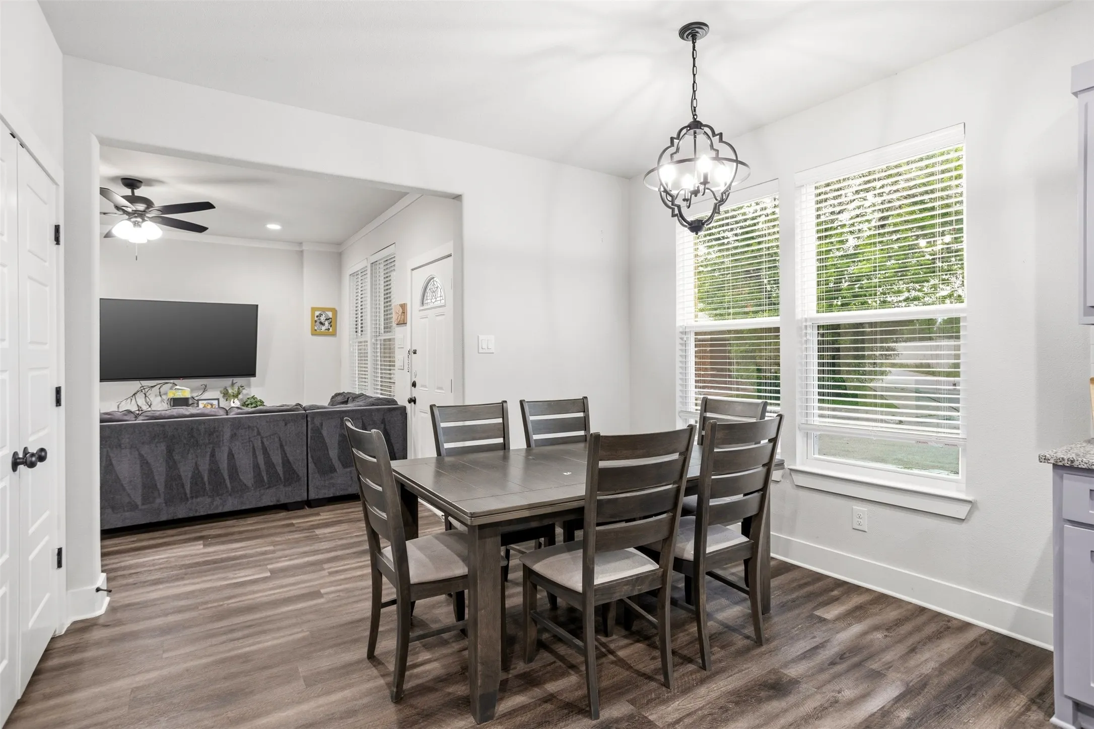 Dining space featuring dark wood-style flooring, a ceiling fan, ornamental molding, and hanging lights