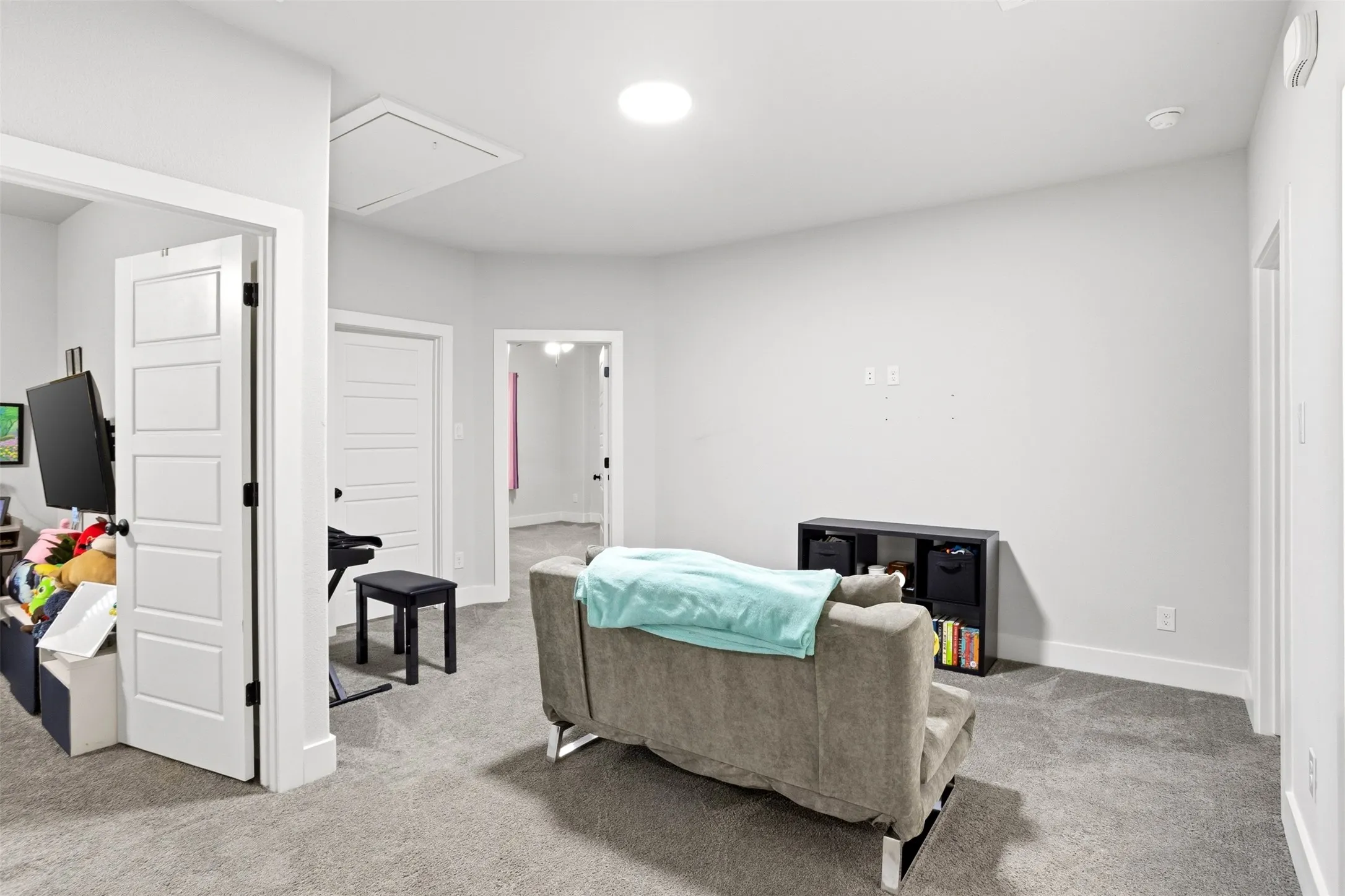 Sitting room featuring attic access and light colored carpet