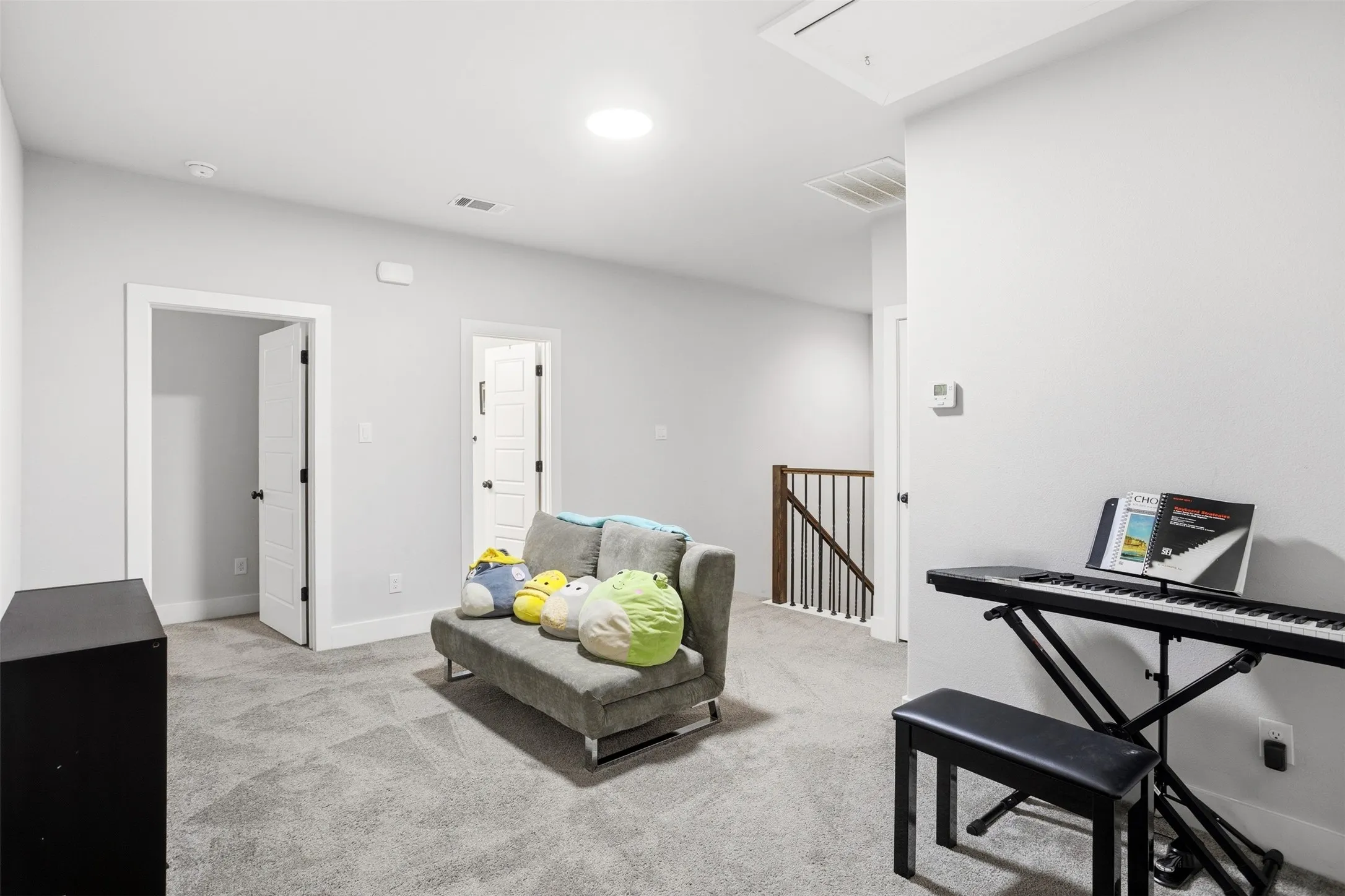 Sitting room featuring an upstairs landing and light colored carpet